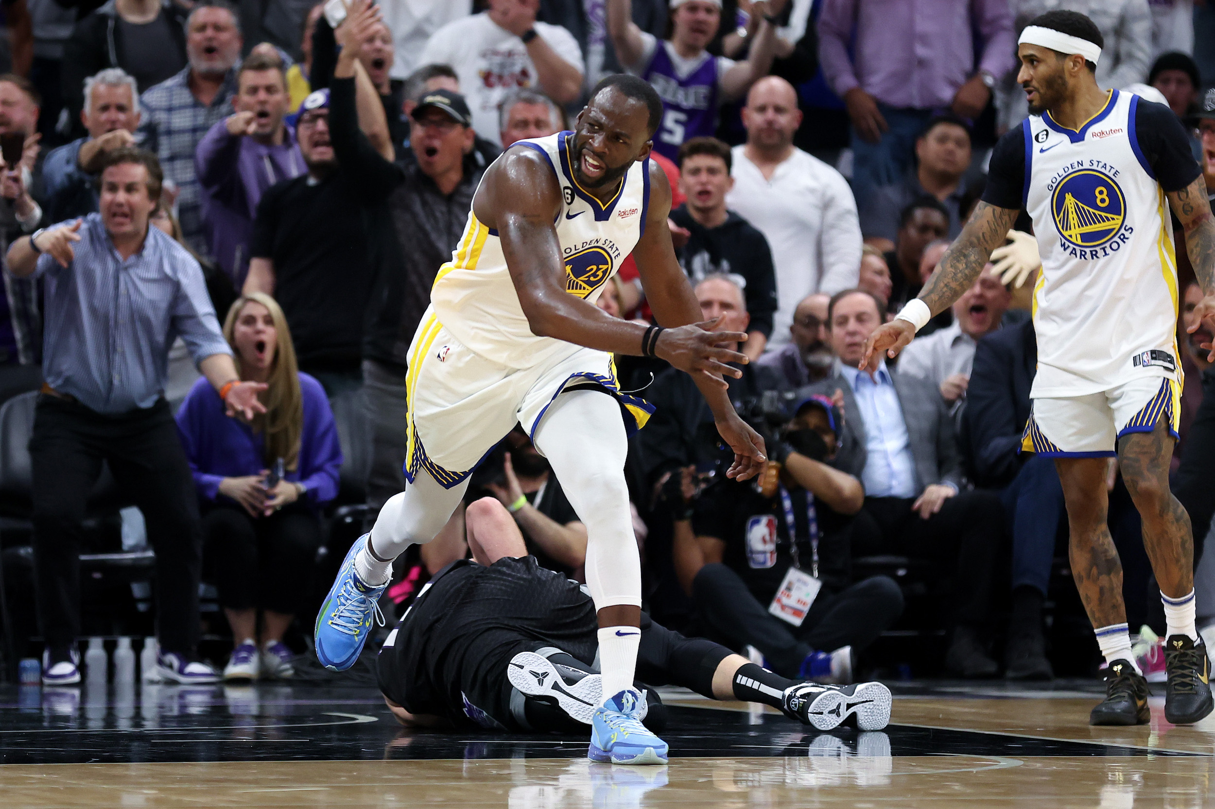 Draymond Green makes a face after stepping on the chest of Domantas Sabonis.