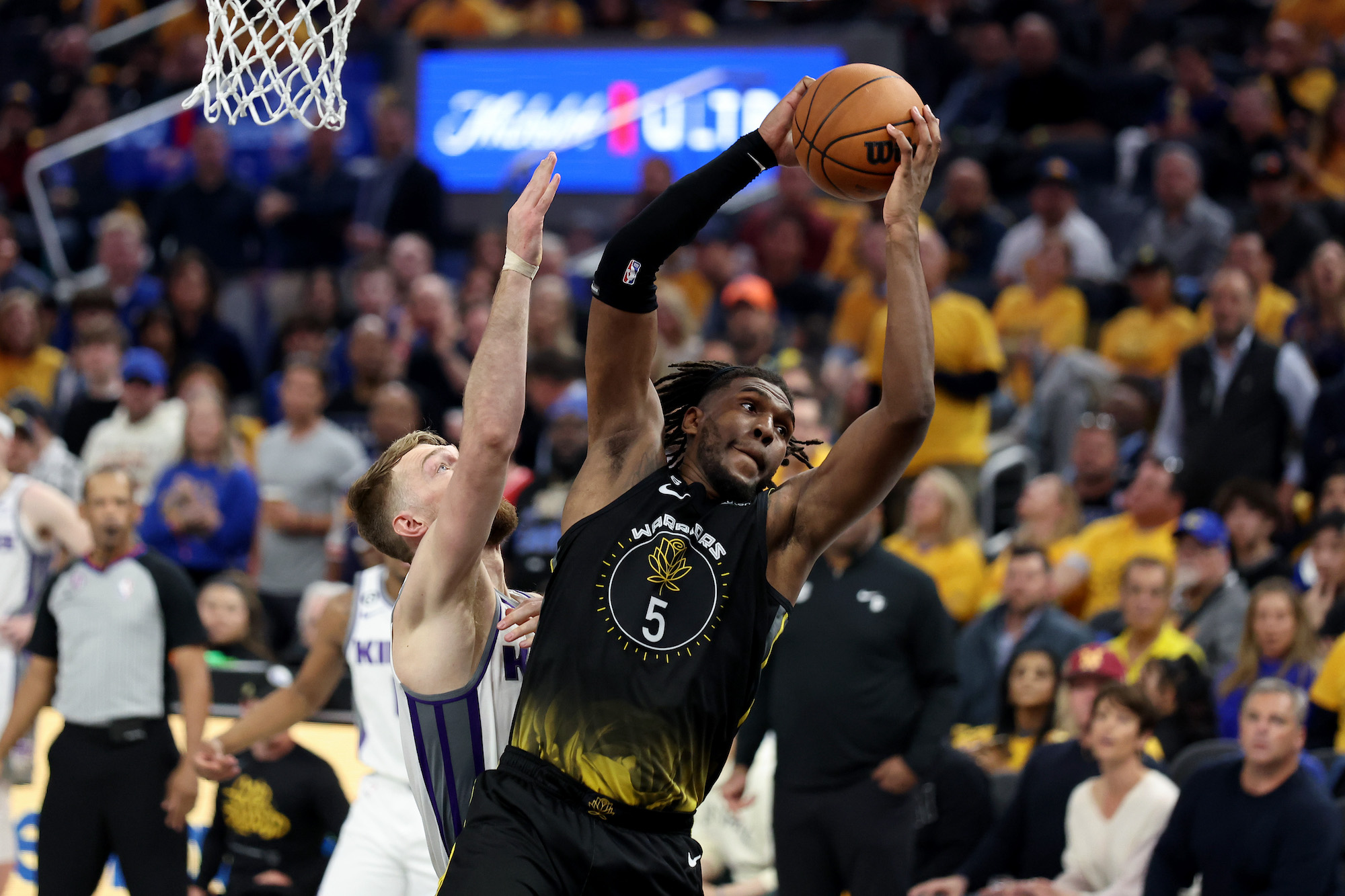 SAN FRANCISCO, CALIFORNIA - APRIL 20: Kevon Looney #5 of the Golden State Warriors and Domantas Sabonis #10 of the Sacramento Kings go for a rebound during Game Three of the Western Conference First Round Playoffs at Chase Center on April 20, 2023 in San Francisco, California. NOTE TO USER: User expressly acknowledges and agrees that, by downloading and or using this photograph, User is consenting to the terms and conditions of the Getty Images License Agreement. (Photo by Ezra Shaw/Getty Images)