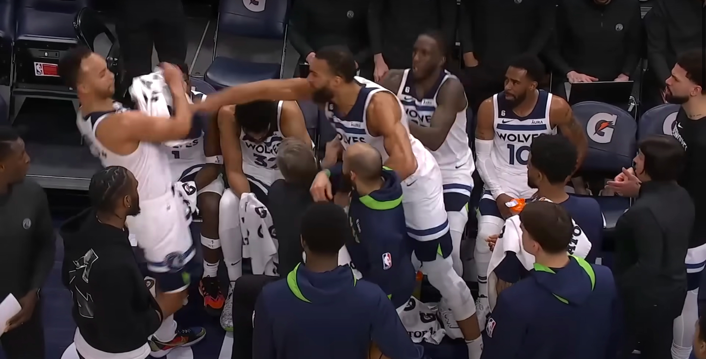 Rudy Gobert swings at Kyle Anderson in a team huddle.
