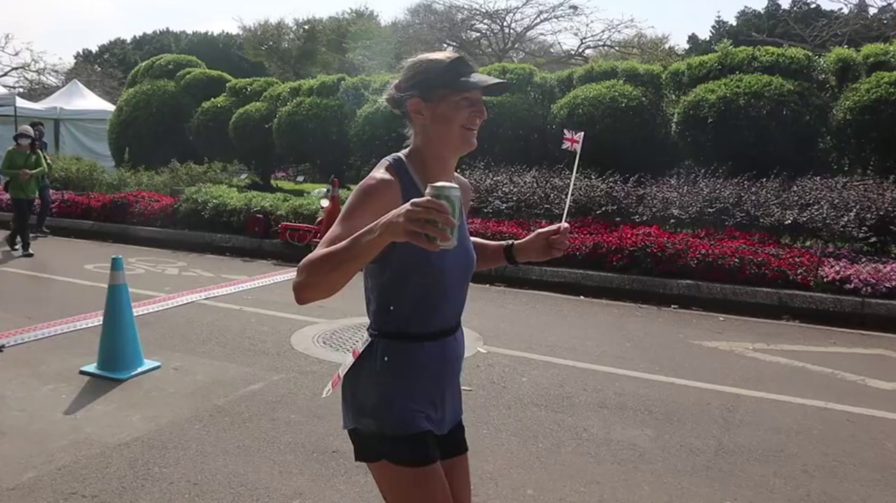 Joasia Zakrzweski runs in the Taipei 48-Hour Run, holding a UK flag