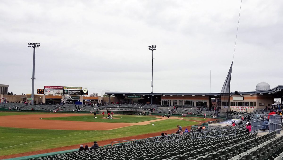 An image of the baseball field at Stockton Ballpark in Stockton, California. There's a baseball field, and rows of plastic chairs for fans to sit in.