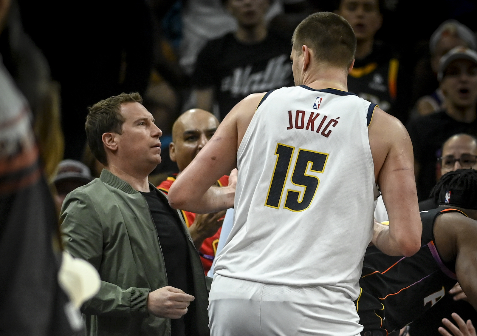 PHOENIX, AZ - MAY 7: Nikola Jokic (15) of the Denver Nuggets slightly stares at Phoenix Suns owner Mat Ishbia before would Ishbia theatrically fall back into his seat after Suns player Josh Okogie (2) flew into the stands during the second quarter at Footprint Center in Phoenix on Sunday, May 7, 2023.