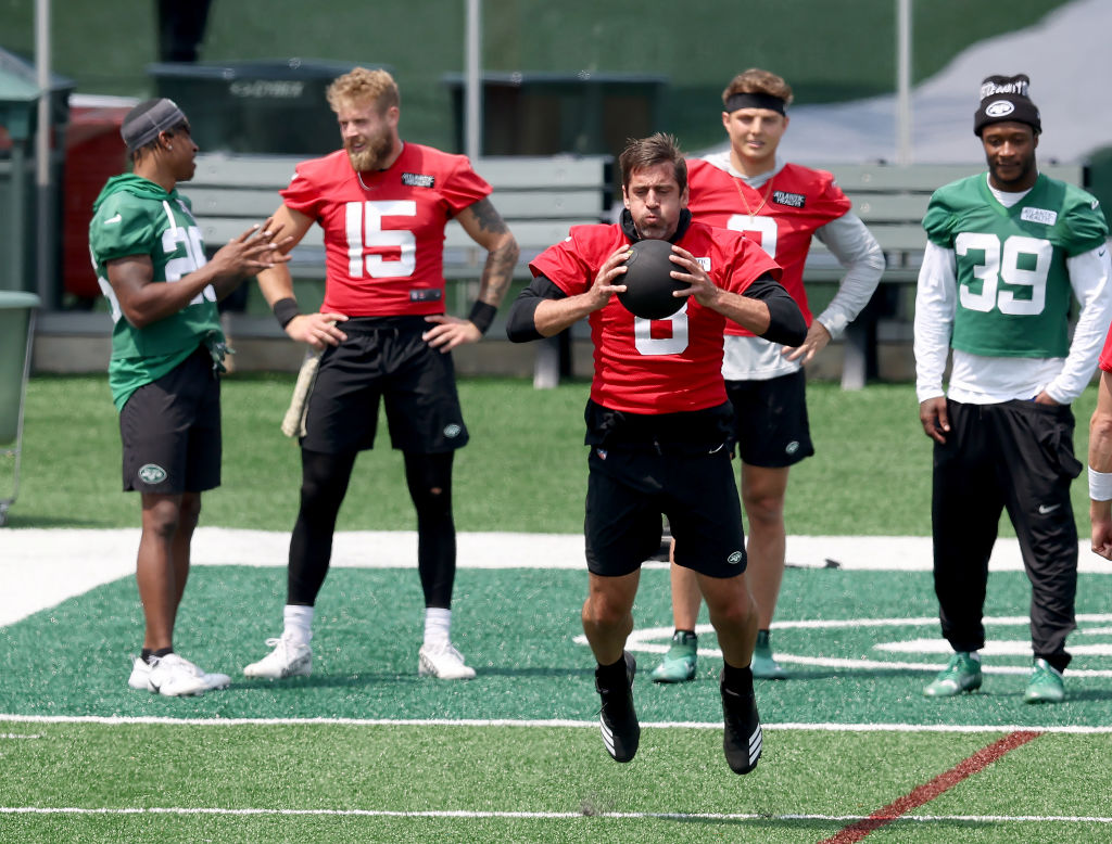 Aaron Rodgers #8 of the New York Jets takes his turn during a warm up drill with a medicine ball as teammate Zach Wilson #2 looks on during an offseason workout session at Atlantic Health Jets Training Center on May 23, 2023 in Florham Park, New Jersey.