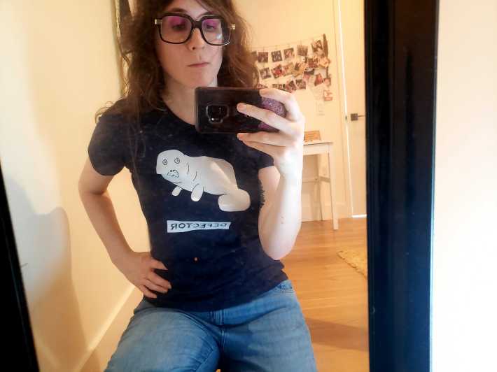 Lauren taking a normal mirror pic while wearing the Devin t-shirt.