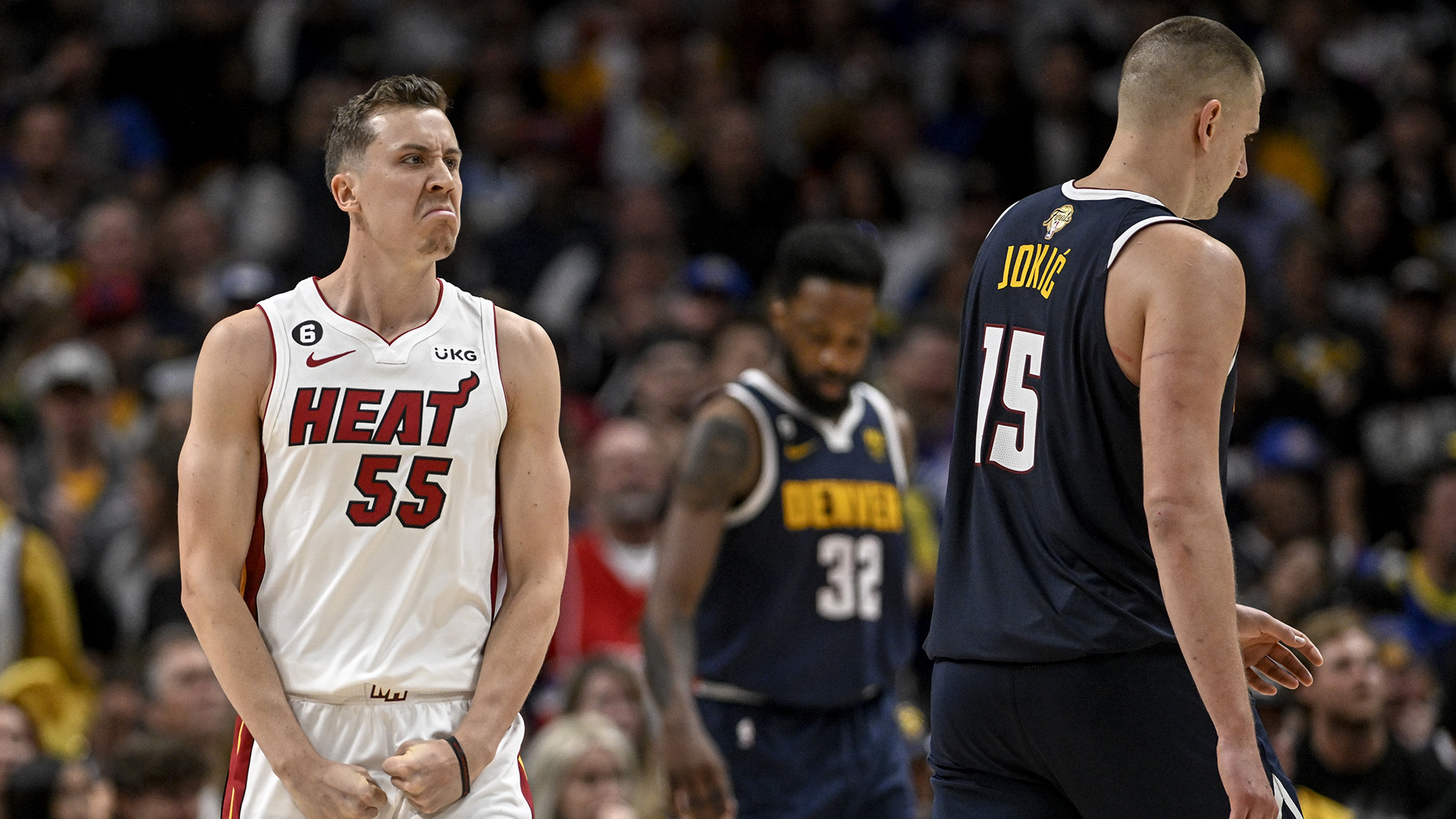 Duncan Robinson (55) of the Miami Heat flexes after a strong finish as Nikola Jokic (15) and Denver Nuggets teammates head to the bench for a timeout in the fourth quarter of Miami's 111-108 win during Game 2 of the NBA Finals at Ball Arena in Denver on Sunday, June 4, 2023