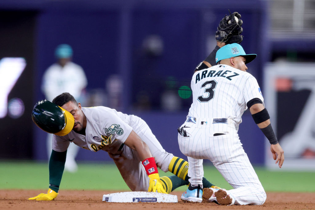 An A's player slides into second base