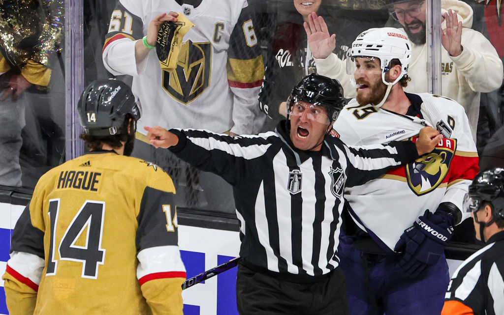 Linesman Jonny Murray separates Nicolas Hague #14 of the Vegas Golden Knights and Matthew Tkachuk #19 of the Florida Panthers during a fight