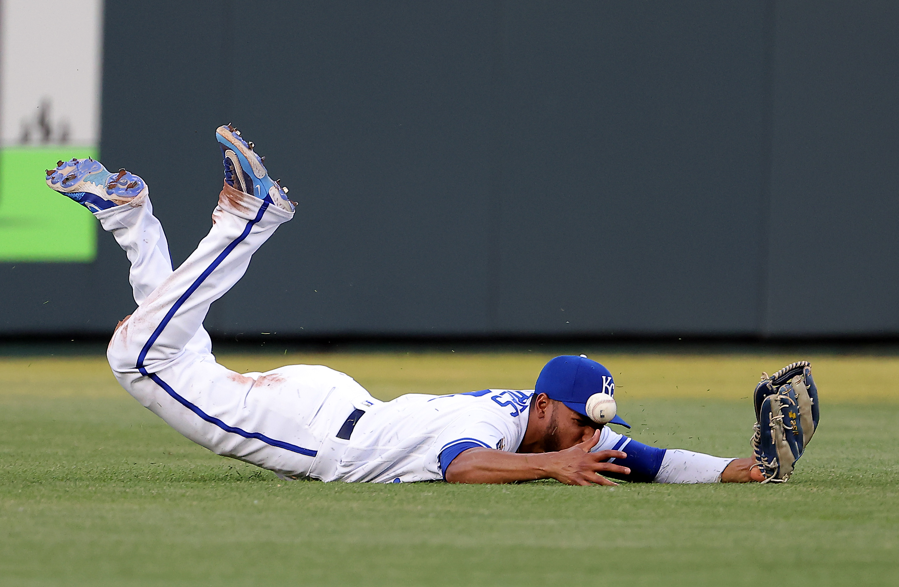 Edward Olivares #14 of the Kansas City Royals dives for but misses the ball in the outfield during the 4th inning of the game against the Cincinnati Reds at Kauffman Stadium on June 14, 2023 in Kansas City, Missouri.