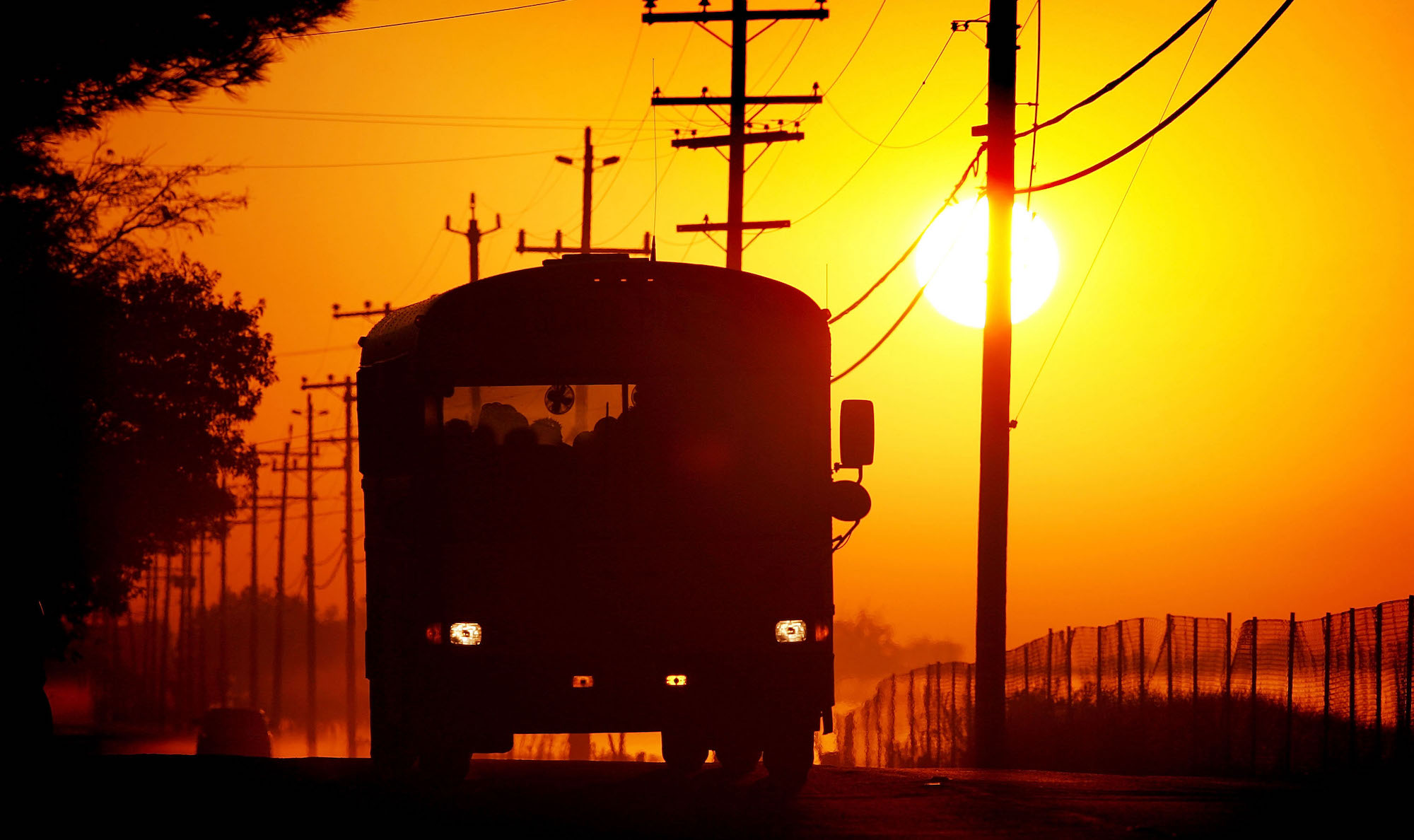 STOCKTON, CA - SEPTEMBER 29: A school bus carries children at sunrise on Bethel Island, one of the residential islands surrounded by levees that hold back the higher waters of the Sacramento-San Joaquin River Delta on September 29, 2005 west of Stockton, California. Officials say that the dikes of the Sacramento-San Joaquin River Delta are in worse shape than those that broke and flooded New Orleans during Hurricane Katrina. There is a two-in-three chance that a catastrophic earthquake or storm in the next 50 years may damage the levees enough to cause the kind of destruction that engulfed New Orleans, according to experts. Such an event would affect the water supply that serves two-thirds of California and create a nightmare traffic jam on Highway 4, the two-lane road that would be the major evacuation route, if it is not damaged beyond usability. Approximately 1,600 miles of levees protect the delta's islands, which lie well below sea-level, and most were built more than 100 years ago. (Photo by David McNew/Getty Images)