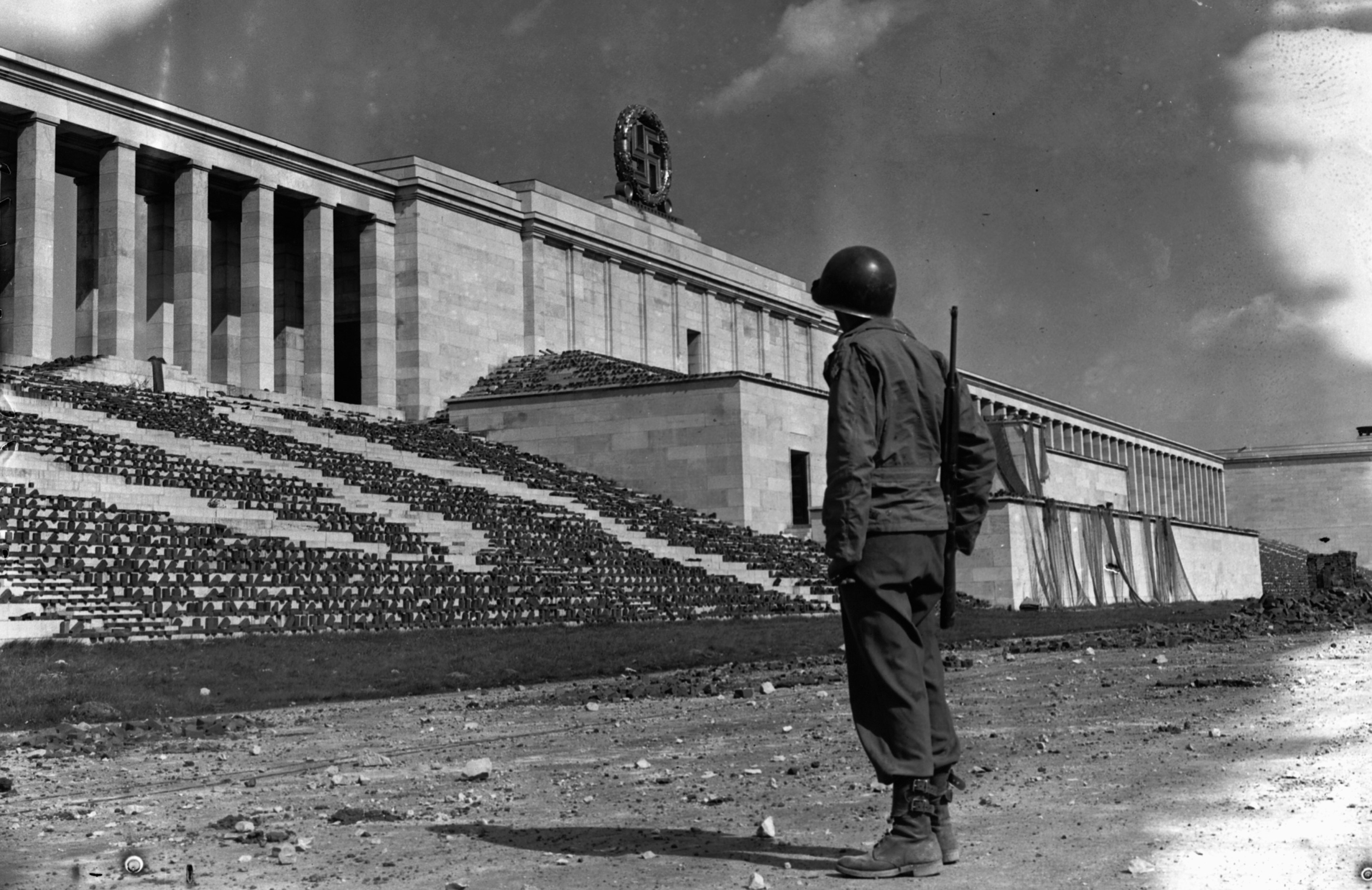 An American soldier stands in the Zeppelin stadium and looks towards a Nazi swastika, Nuremberg, Germany, 1945. The stadium, along with two others, was used by Adolf Hitler to hold many Nazi rallies. (Photo by © Hulton-Deutsch Collection/CORBIS/Corbis via Getty Images)