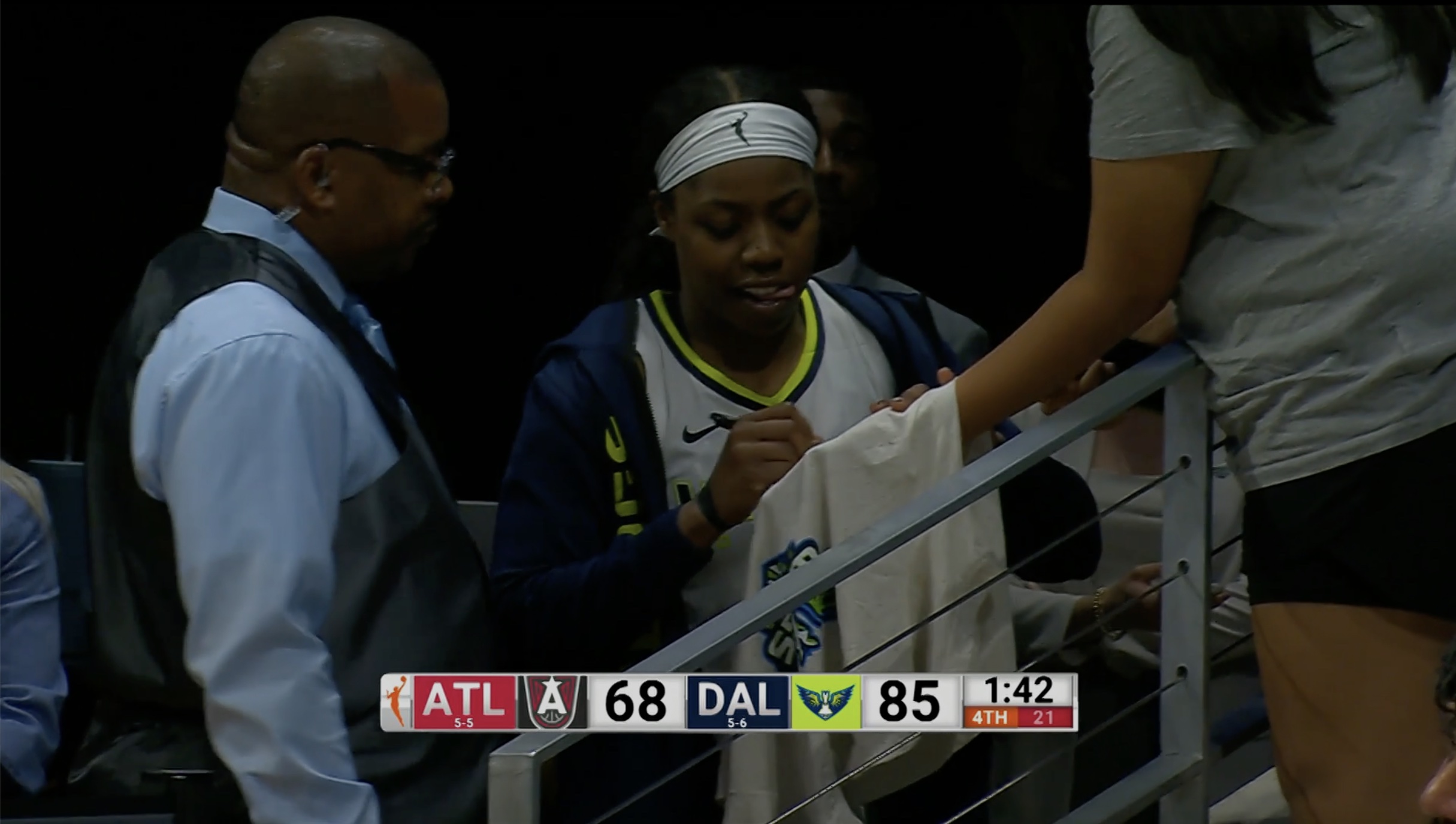 Arike Ogunbowale signs a t-shirt for a fan after being ejected.