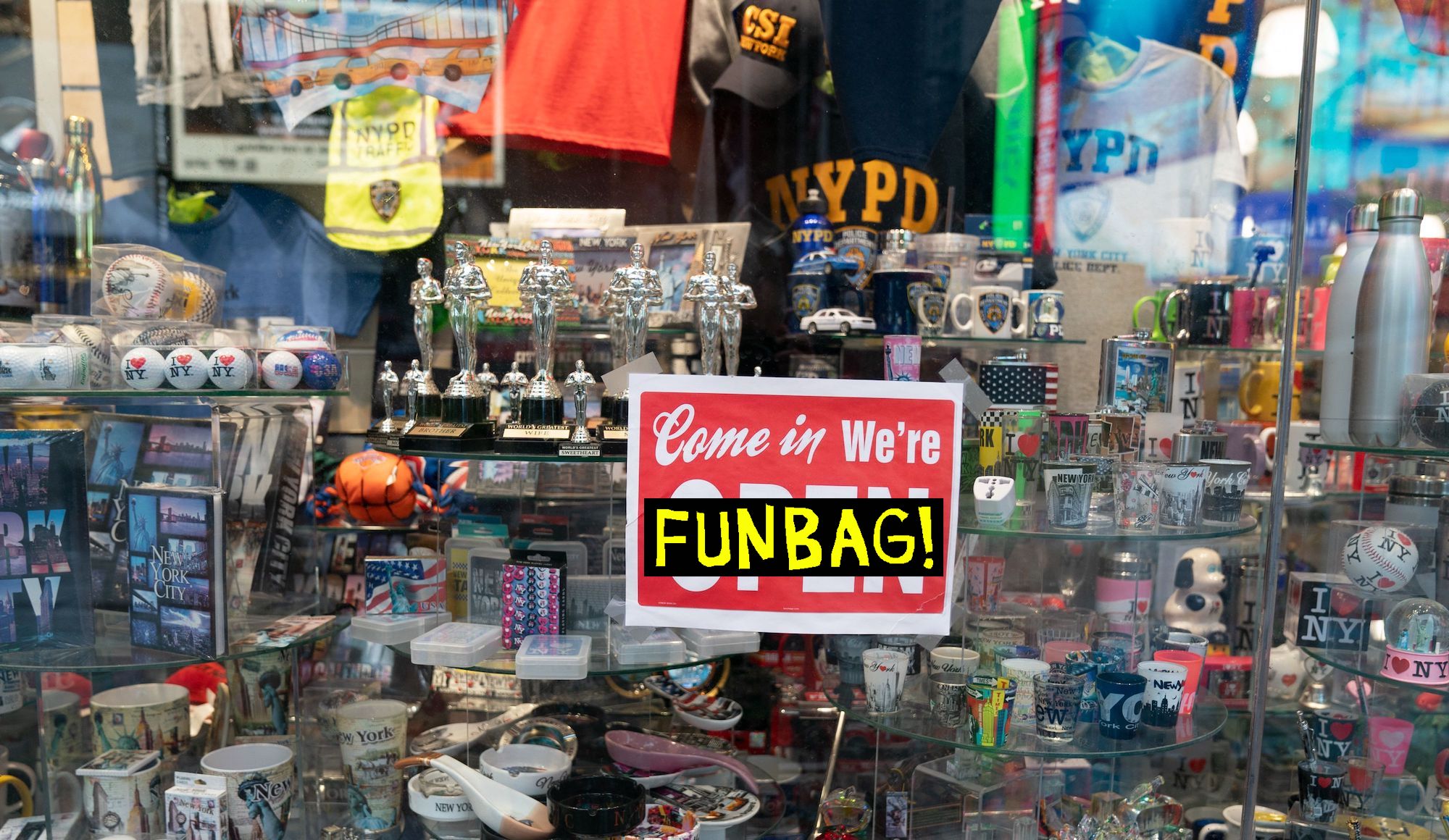 An open sign in the window of a gift shop is seen in Times Square on August 16, 2020 in New York. Five months after New York City shut down to combat the coronavirus, the tourism industry remains flat. Business leaders and City officials are trying to devise plans to revive the tourism industry that has in years past brought in $45 billion annually and supported 300,000 jobs. (Photo by Bryan R. Smith / AFP) (Photo by BRYAN R. SMITH/AFP via Getty Images)