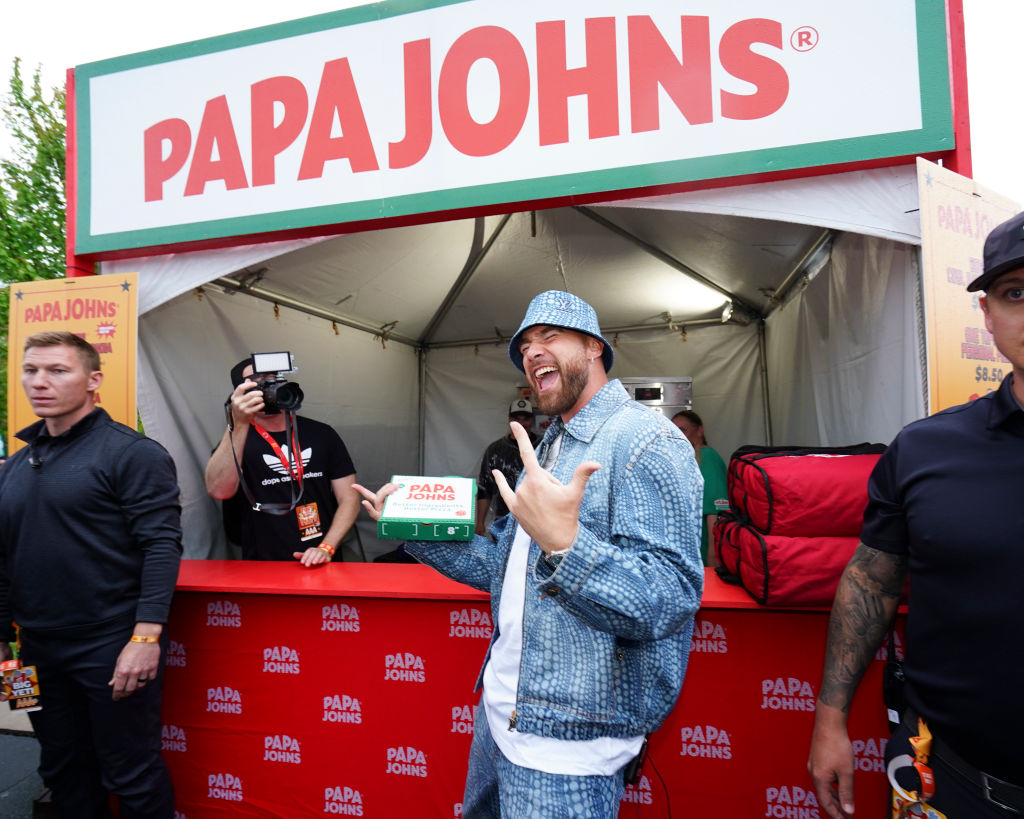 Travis Kelce #52 of the Kansas City Chiefs samples pizza at a Papa Johns food stand during Kelce Jam at Azura Amphitheater on April 28, 2023 in Bonner Springs, Kansas.