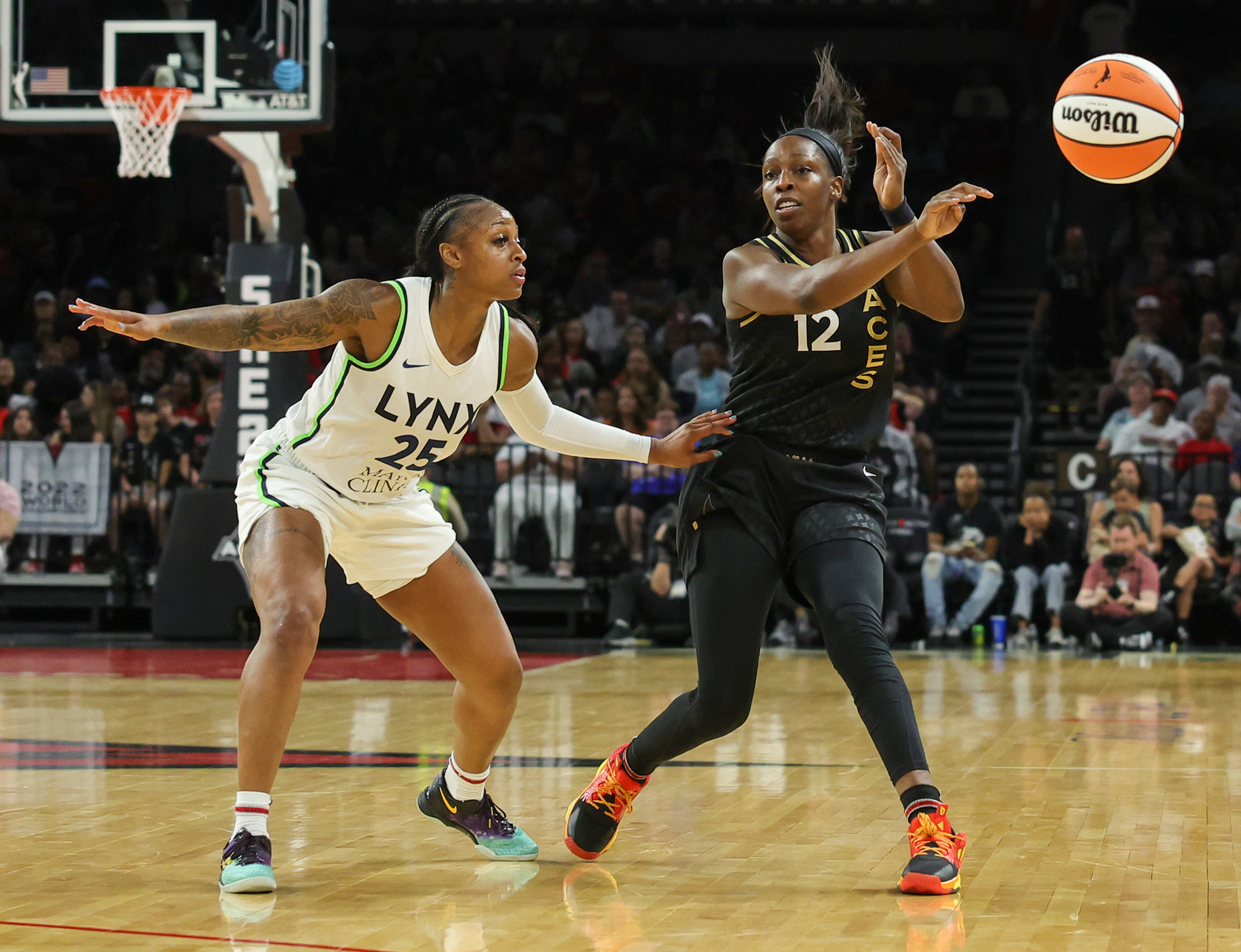 LAS VEGAS, NEVADA - MAY 28: Chelsea Gray #12 of the Las Vegas Aces passes as Tiffany Mitchell #25 of the Minnesota Lynx defends in the fourth quarter of their game at Michelob ULTRA Arena on May 28, 2023 in Las Vegas, Nevada. The Aces defeated the Lynx 94-73.