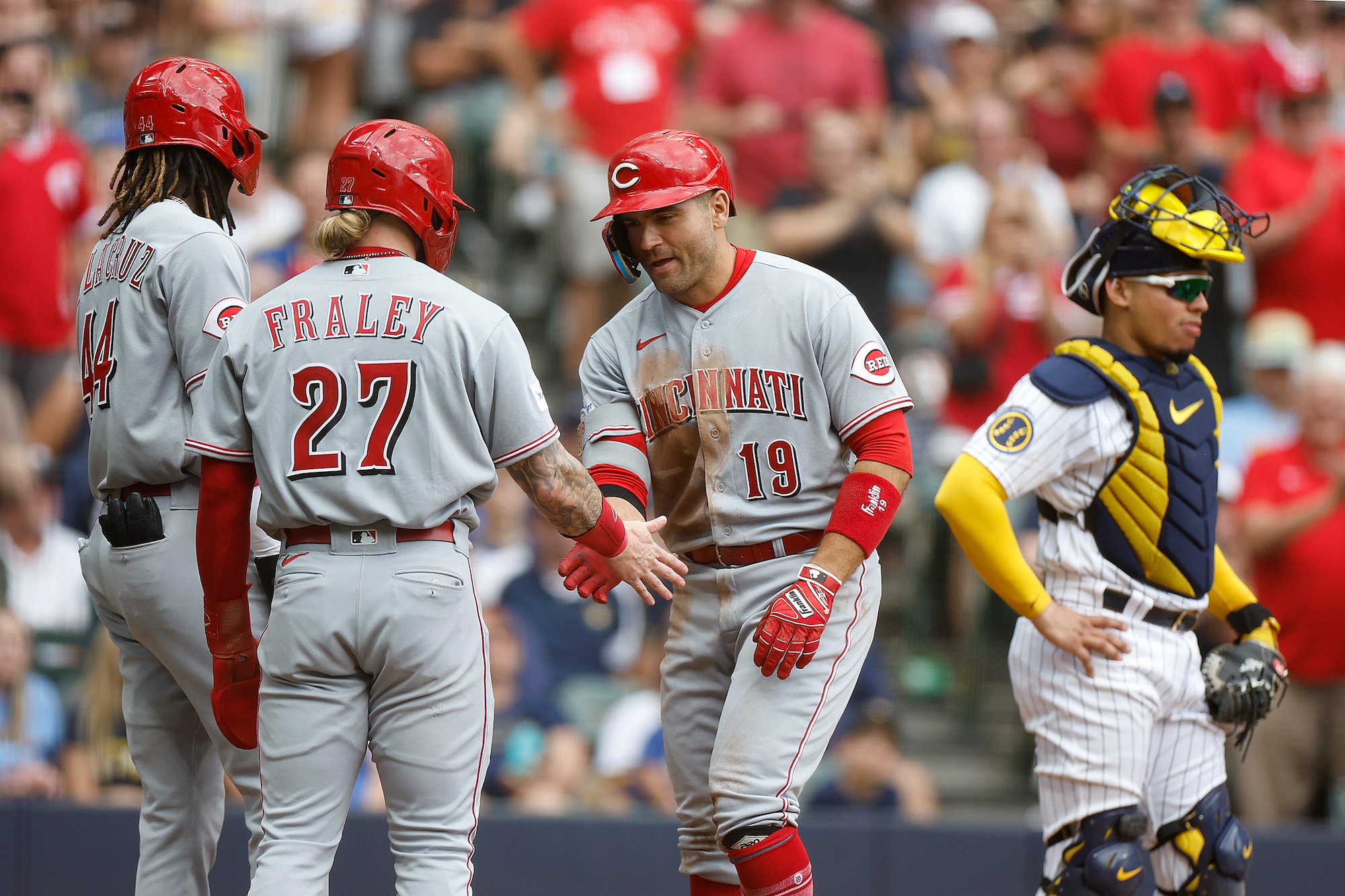 MILWAUKEE, WISCONSIN - JULY 08: Joey Votto #19 of the Cincinnati Reds is congratulated by Elly De La Cruz #44 and Jake Fraley #27 after a three-run home run in the fourth inning against the Milwaukee Brewers at American Family Field on July 08, 2023 in Milwaukee, Wisconsin. (Photo by John Fisher/Getty Images)