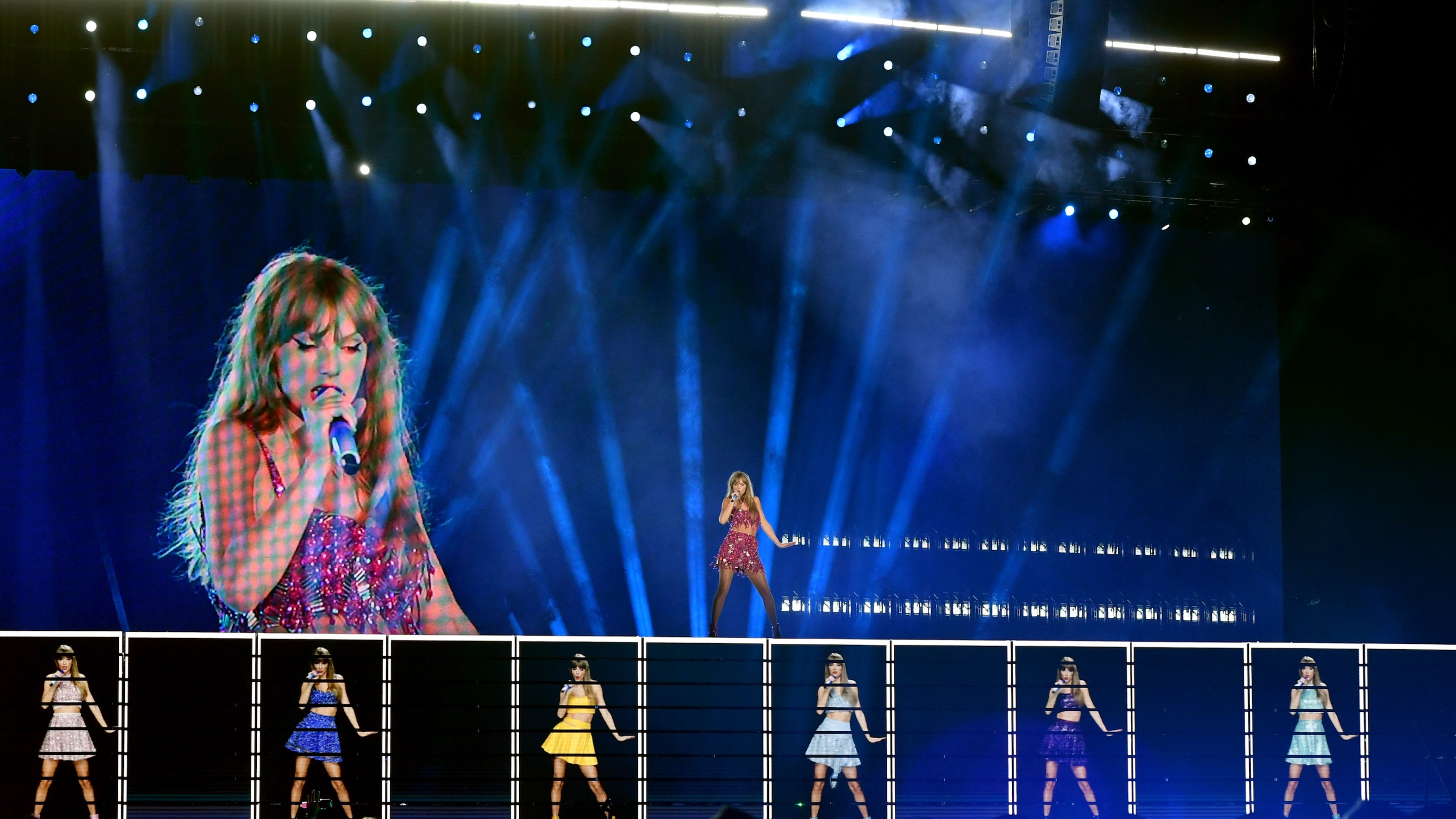 Taylor Swift performing, with some help from a video projection of herself and some other smaller video versions of herself, during her show in Kansas City.