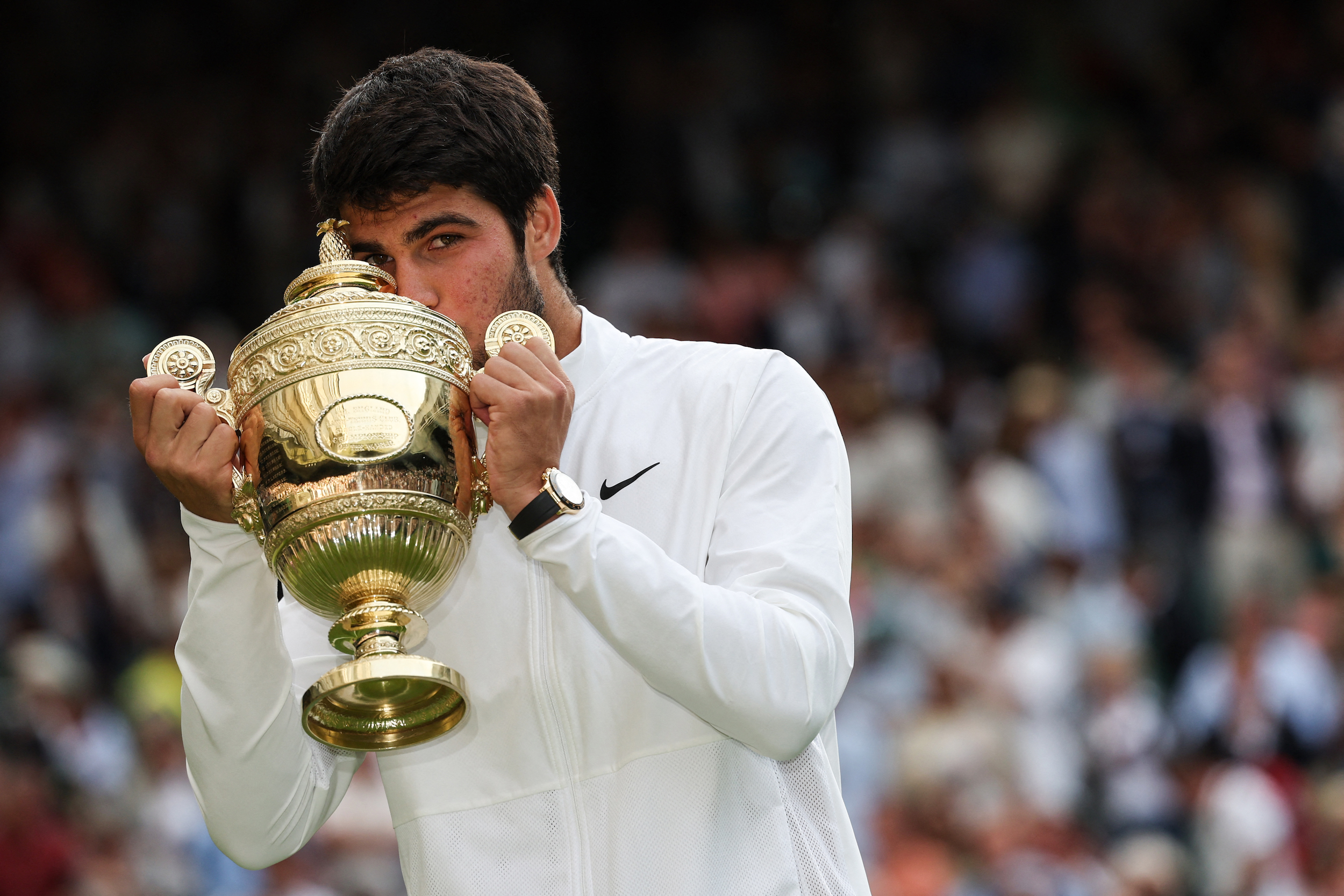 Carlos Alcaraz kisses the Wimbledon trophy