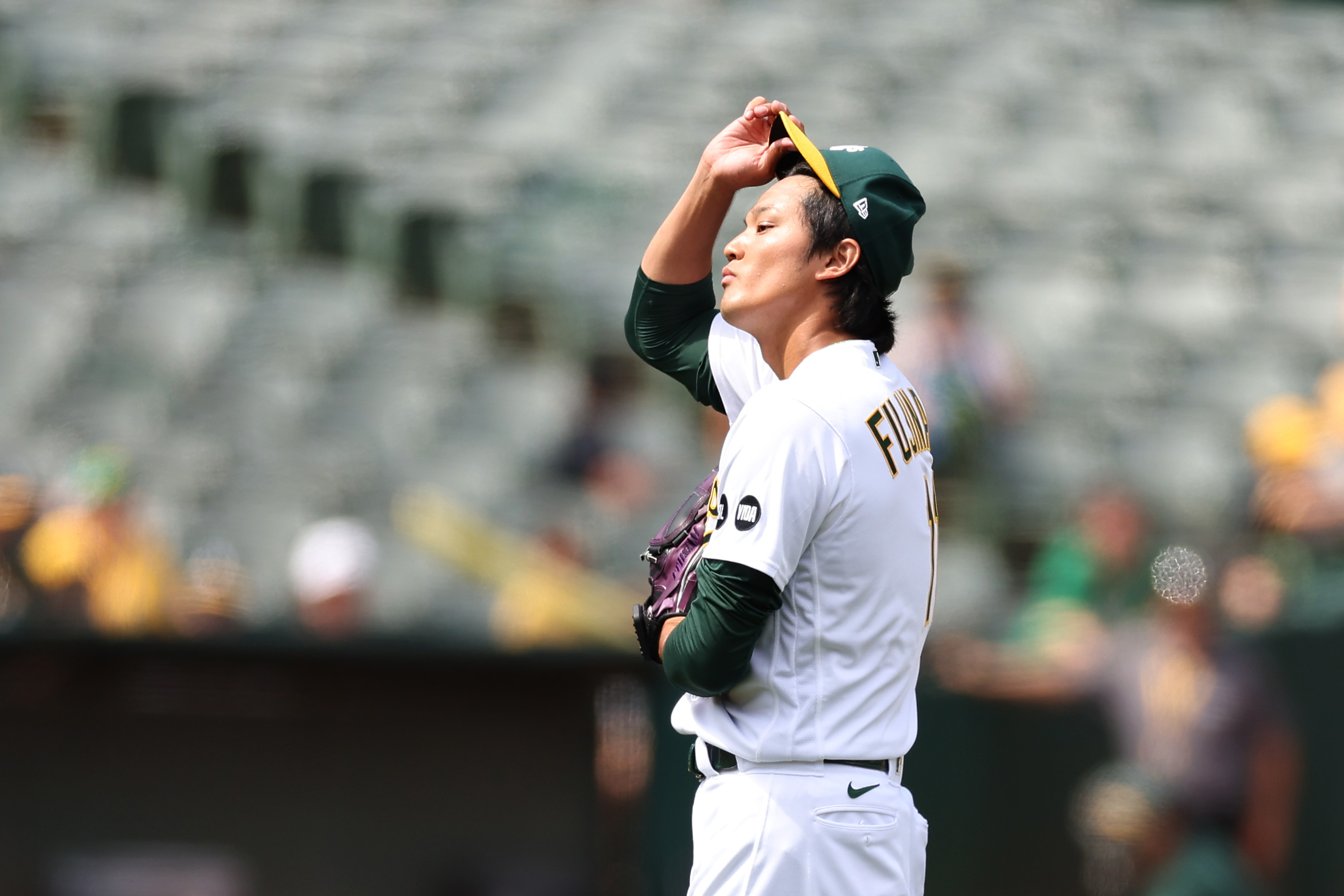 Shintaro Fujinami, in profile, adjusts his cap during an appearance with the Oakland A's on July 16.