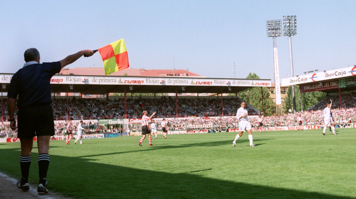Assistant referee raises his flag for offside