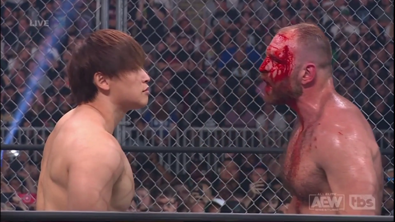 Kota Ibushi stares down a bloody Jon Moxley