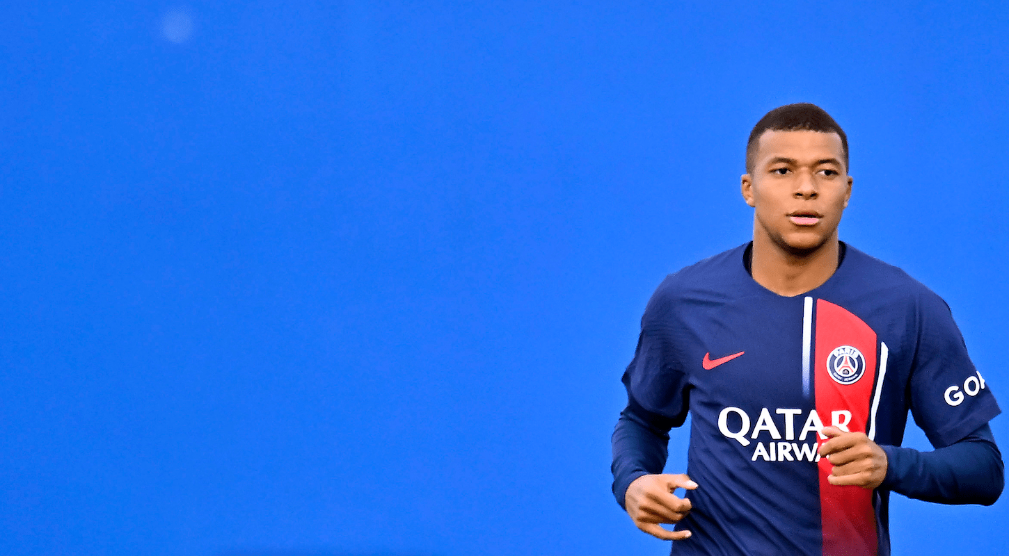 Kylian Mbappé alone against a blue background