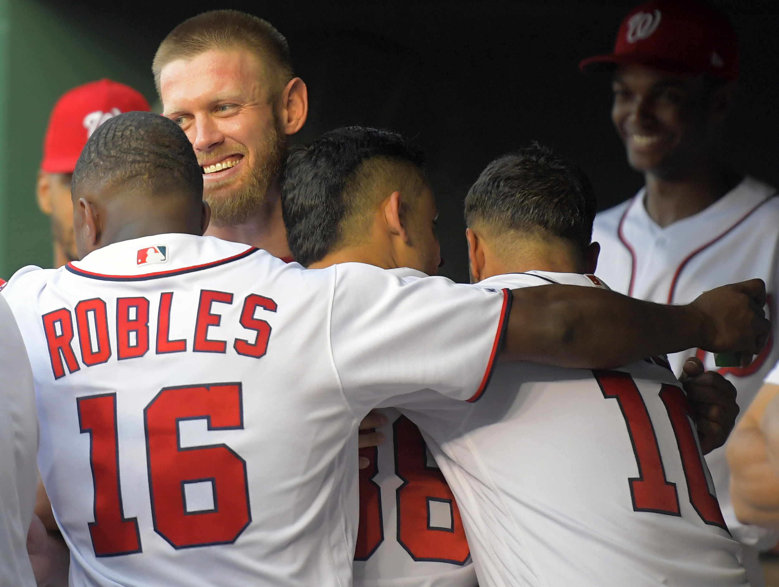 A smiling Stephen Strasburg is enveloped in an involuntary group hug during the 2019 season.