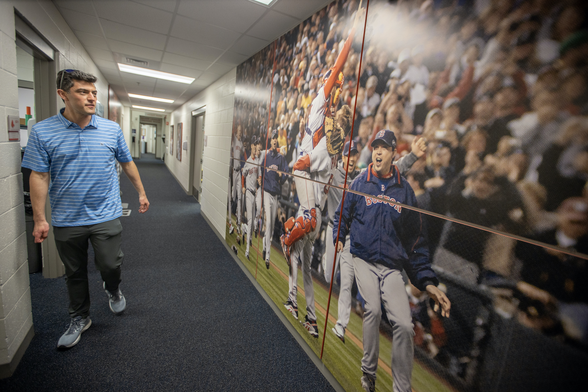 Boston Red Sox Chief Baseball Officer Chaim Bloom walks past a photo of the 2007 Red Sox after they won the World Series.
