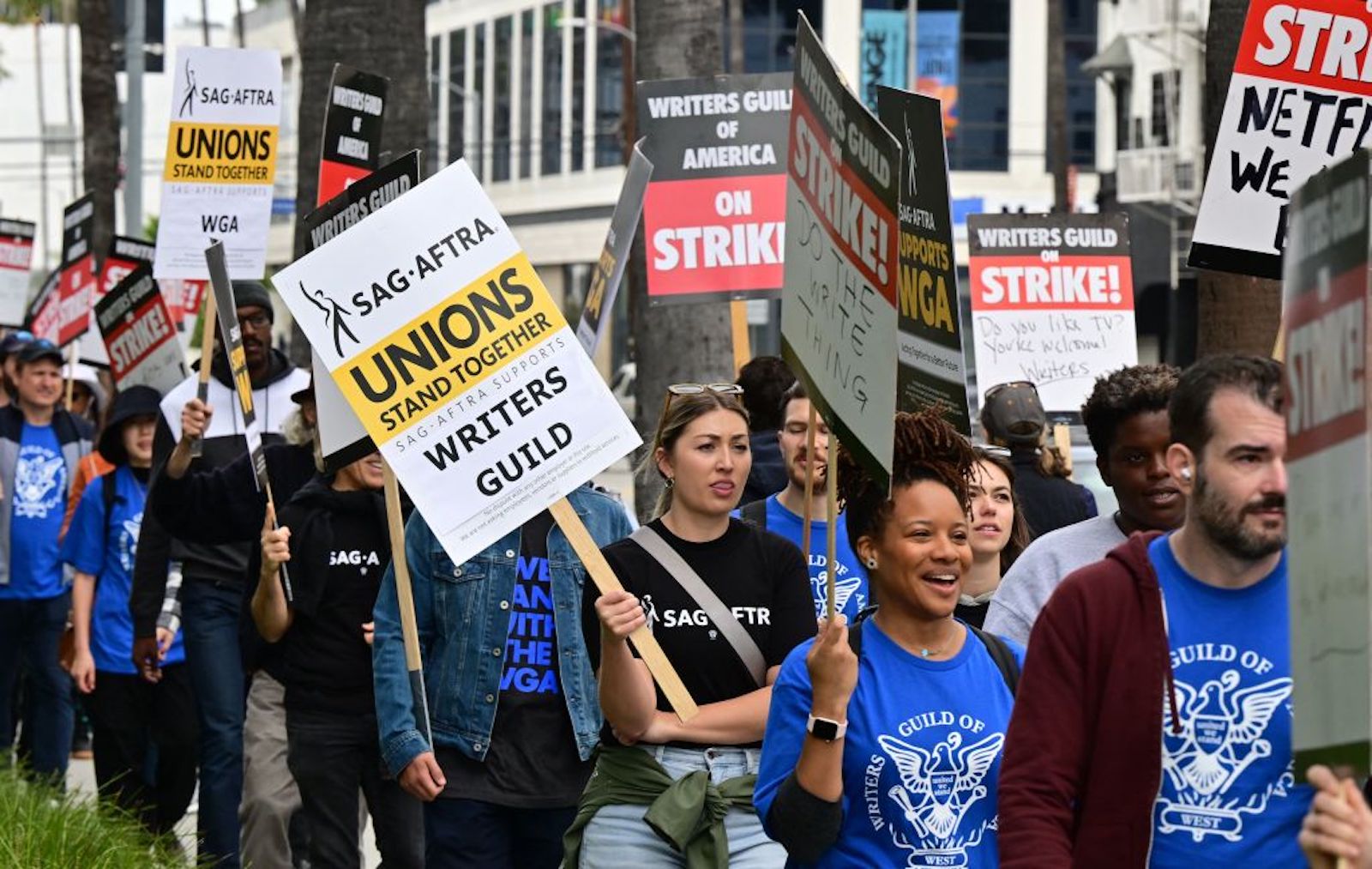 Writers on strike march with signs on the picket line on day four of the strike by the Writers Guild of America in front of Netflix in Hollywood, California on May 5, 2023. - More than 11,000 Hollywood television and movie writers are on their first strike since 2007 after talks with studios and streamers over pay and working conditions failed to clinch a deal.