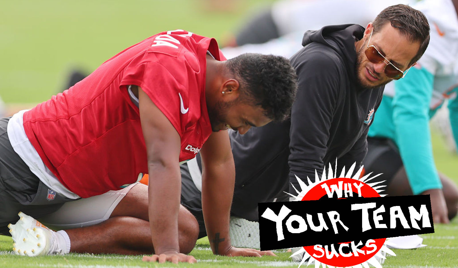 MIAMI GARDENS, FLORIDA - JULY 27: Head coach Mike McDaniel of the Miami Dolphins stretches with Tua Tagovailoa #1 during training camp at Baptist Health Training Complex on July 27, 2022 in Miami Gardens, Florida.