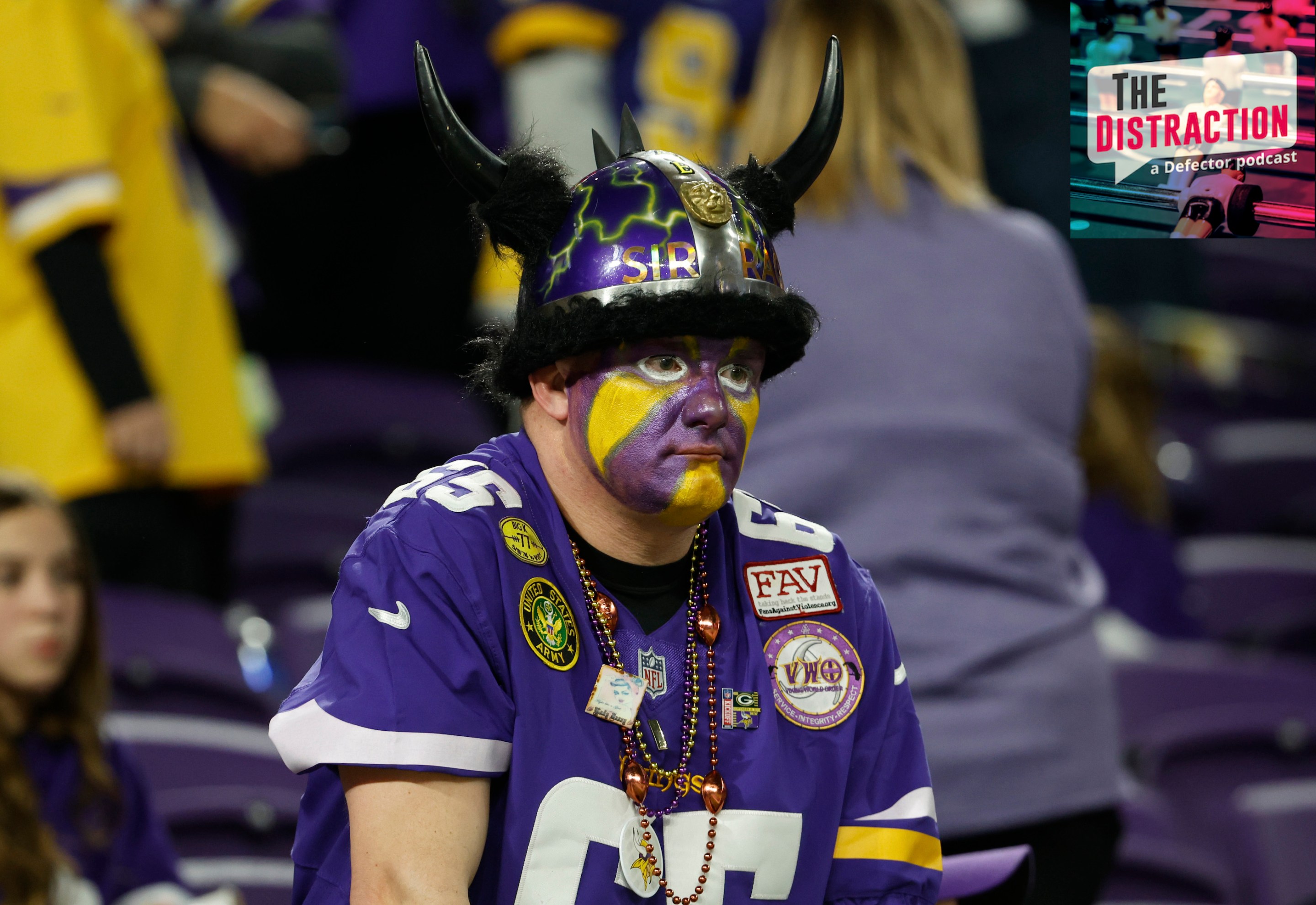 A Minnesota Vikings fan with a painted face and a goofy horned helmet looks contemplative/despondent during the team's loss to the New York Giants in the 2023 NFC Wild Card game.