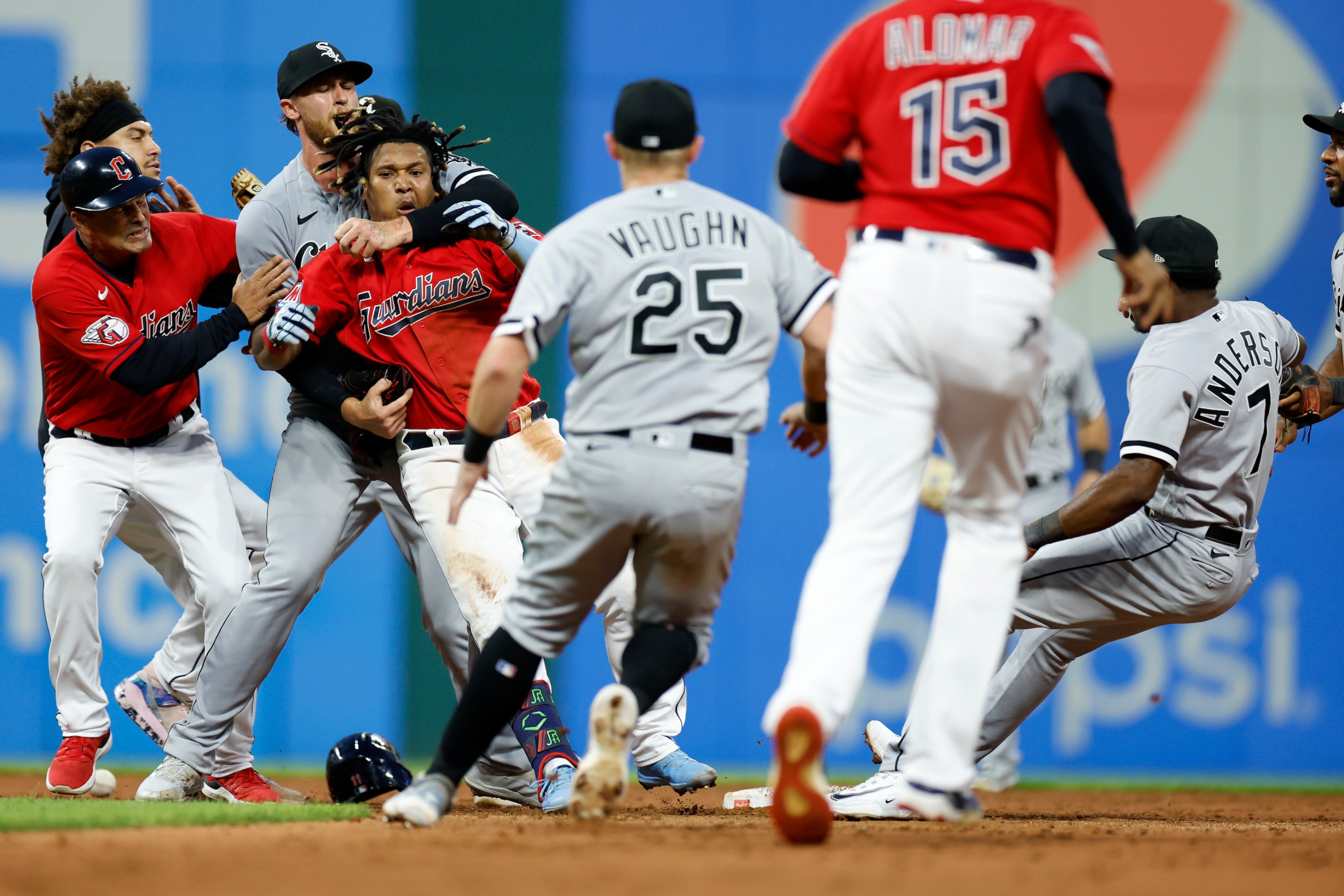 Jose Ramirez of the Cleveland Guardians is restrained by White Sox pitcher Michael Kopech after landing a heavy right hook to White Sox shortstop Tim Anderson's jaw during a game on August 5.