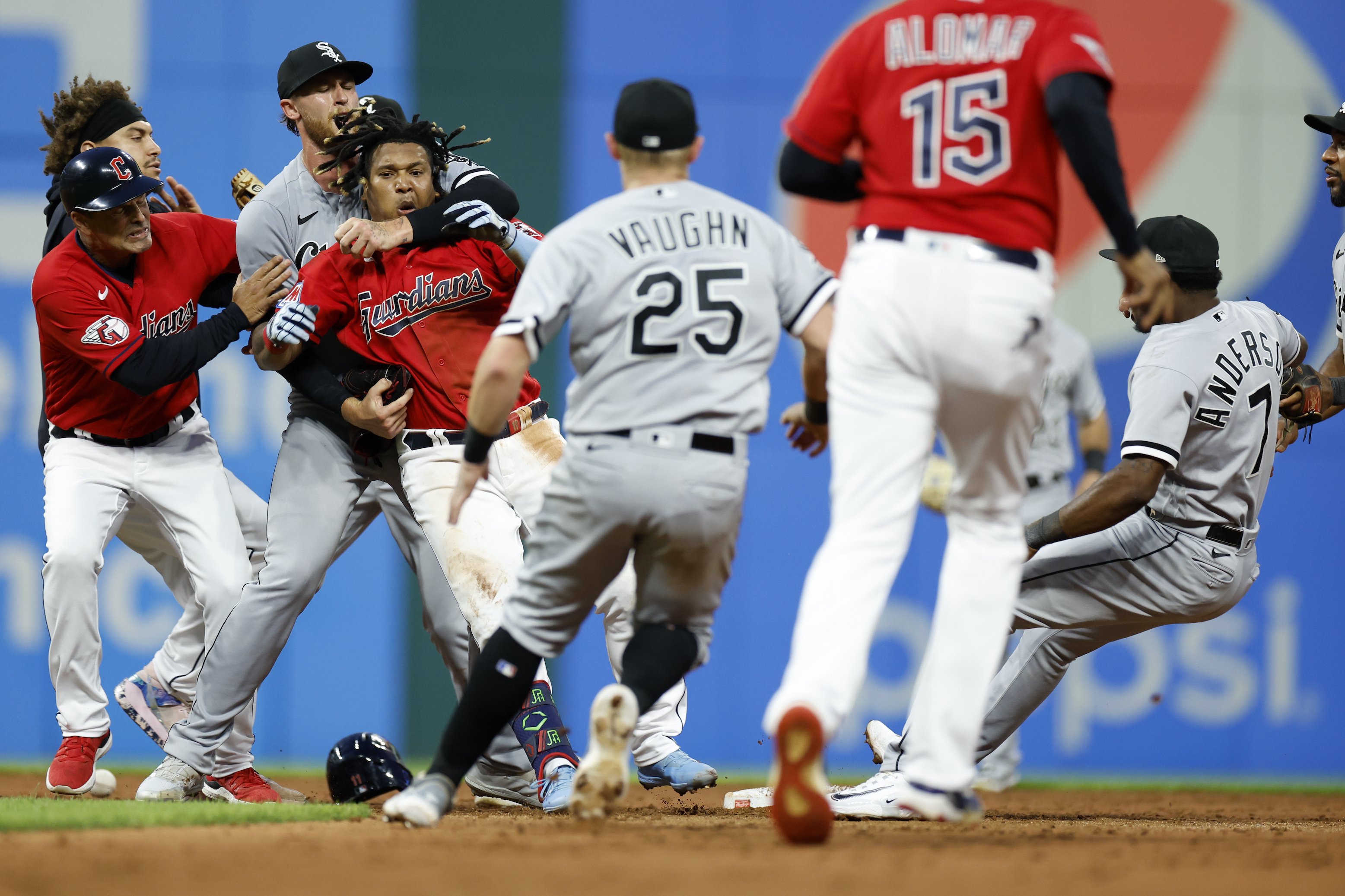 Jose Ramirez of the Cleveland Guardians is restrained by White Sox pitcher Michael Kopech after landing a heavy right hook to White Sox shortstop Tim Anderson's jaw during a game on August 5.