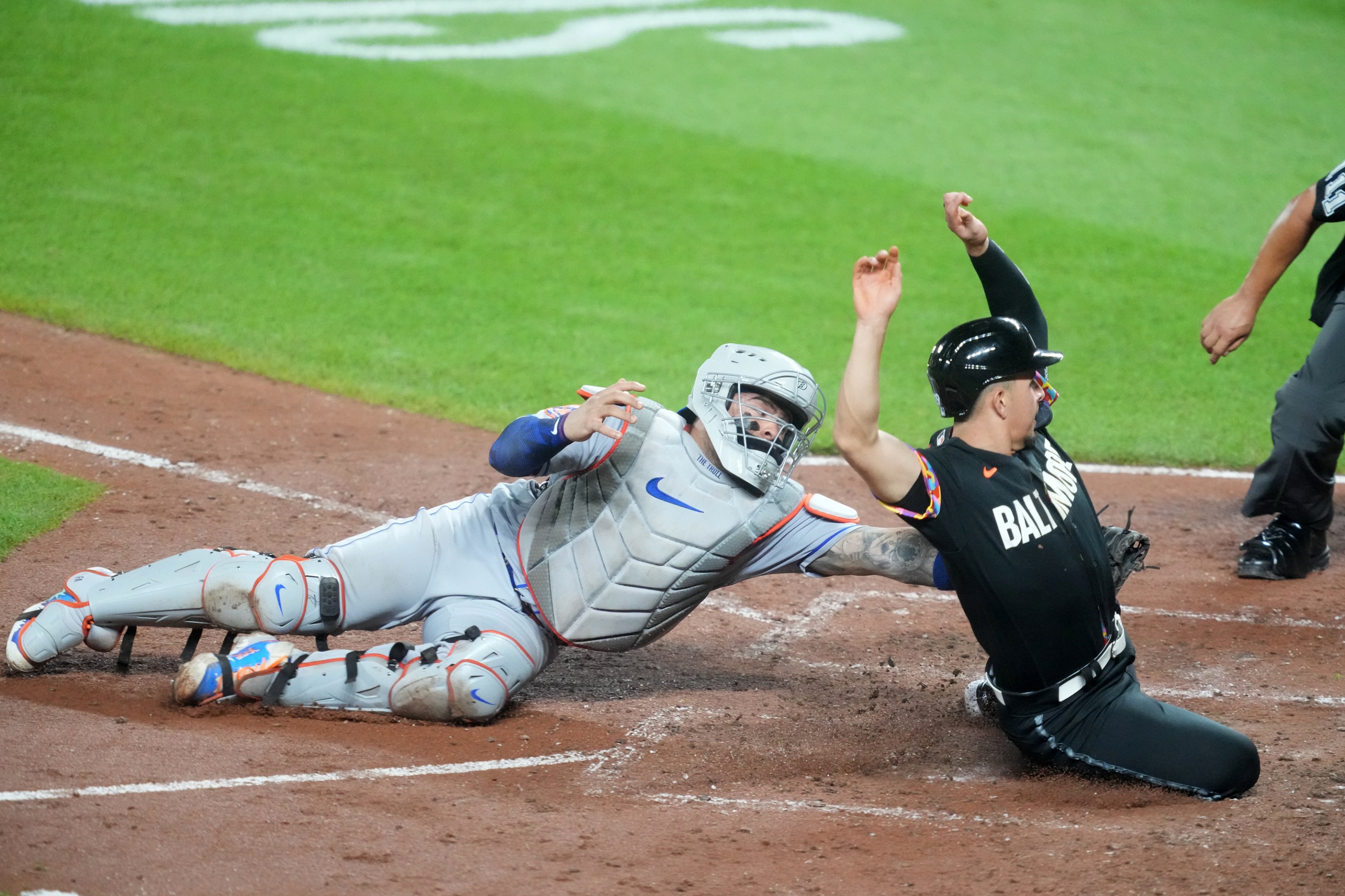 Orioles infielder Ramon Urias slides in under the tag of Mets catcher Francisco Alvarez in an Orioles win on August 4, 2023.