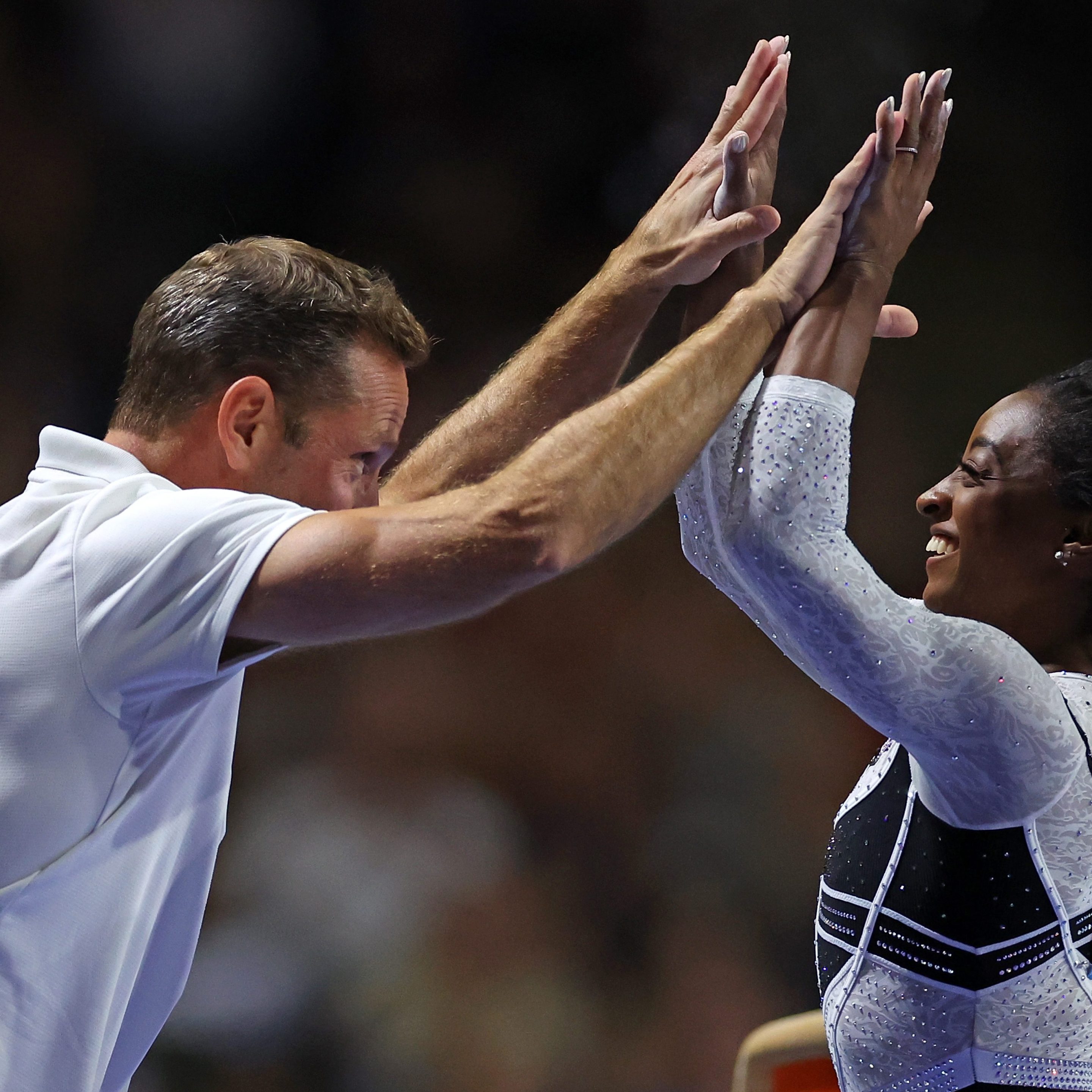 Simone Biles celebrates with her coach Laurent Landi after competing on the vault at the Core Hydration Classic at Now Arena on August 05, 2023 in Hoffman Estates, Illinois.