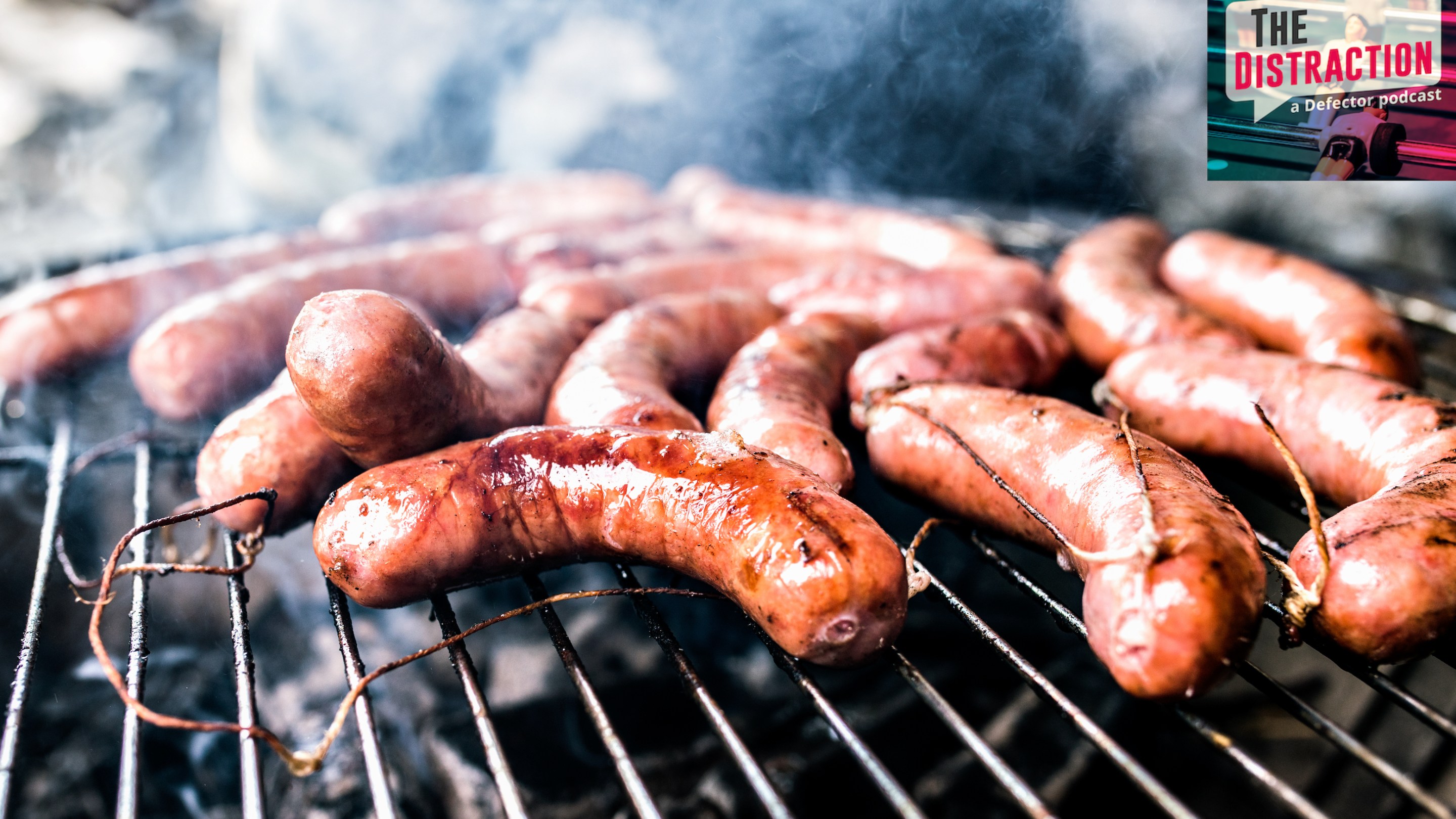 A stock photo of sausages cooking on a barbecue grill.