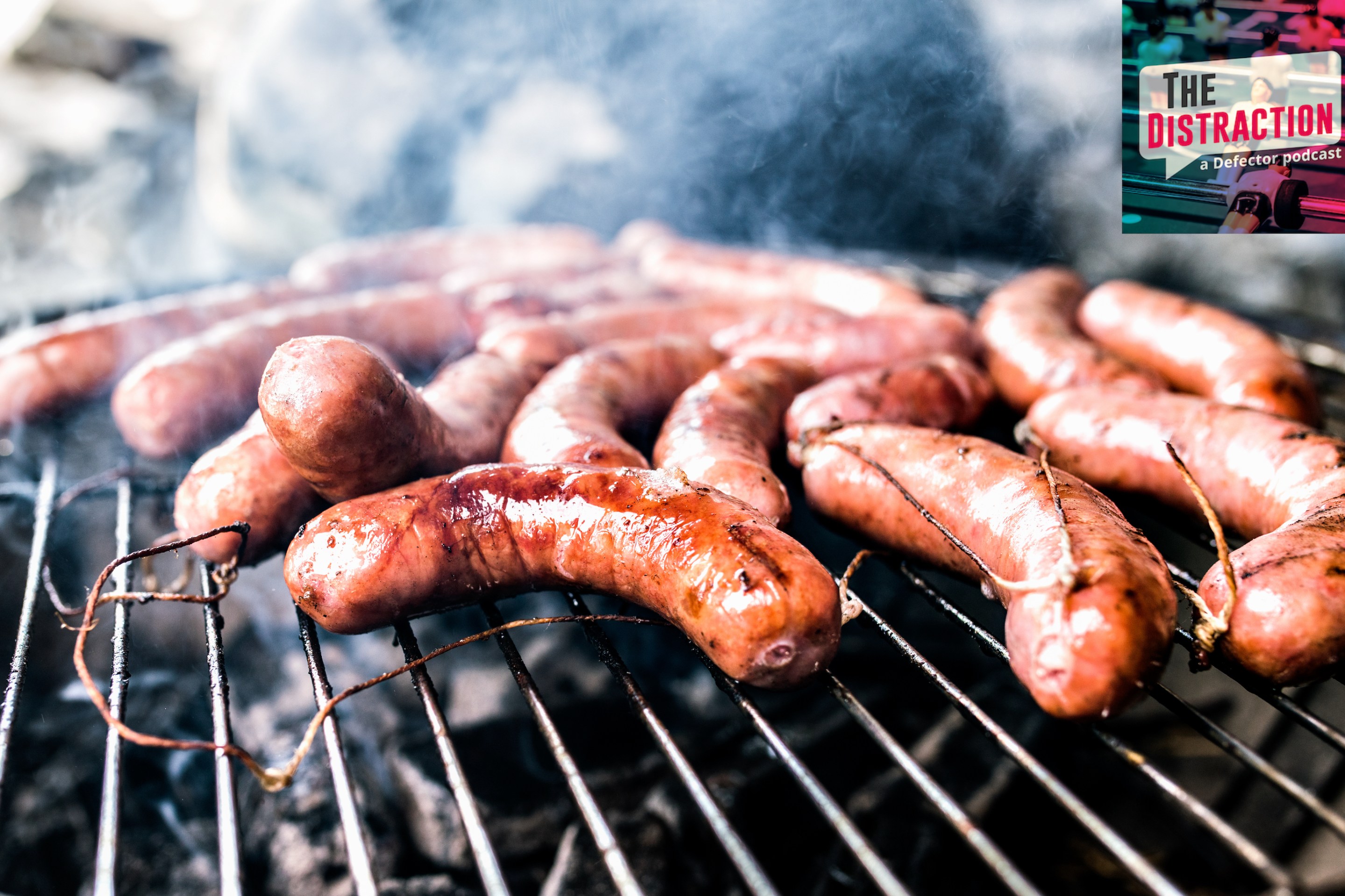 A stock photo of sausages cooking on a barbecue grill.