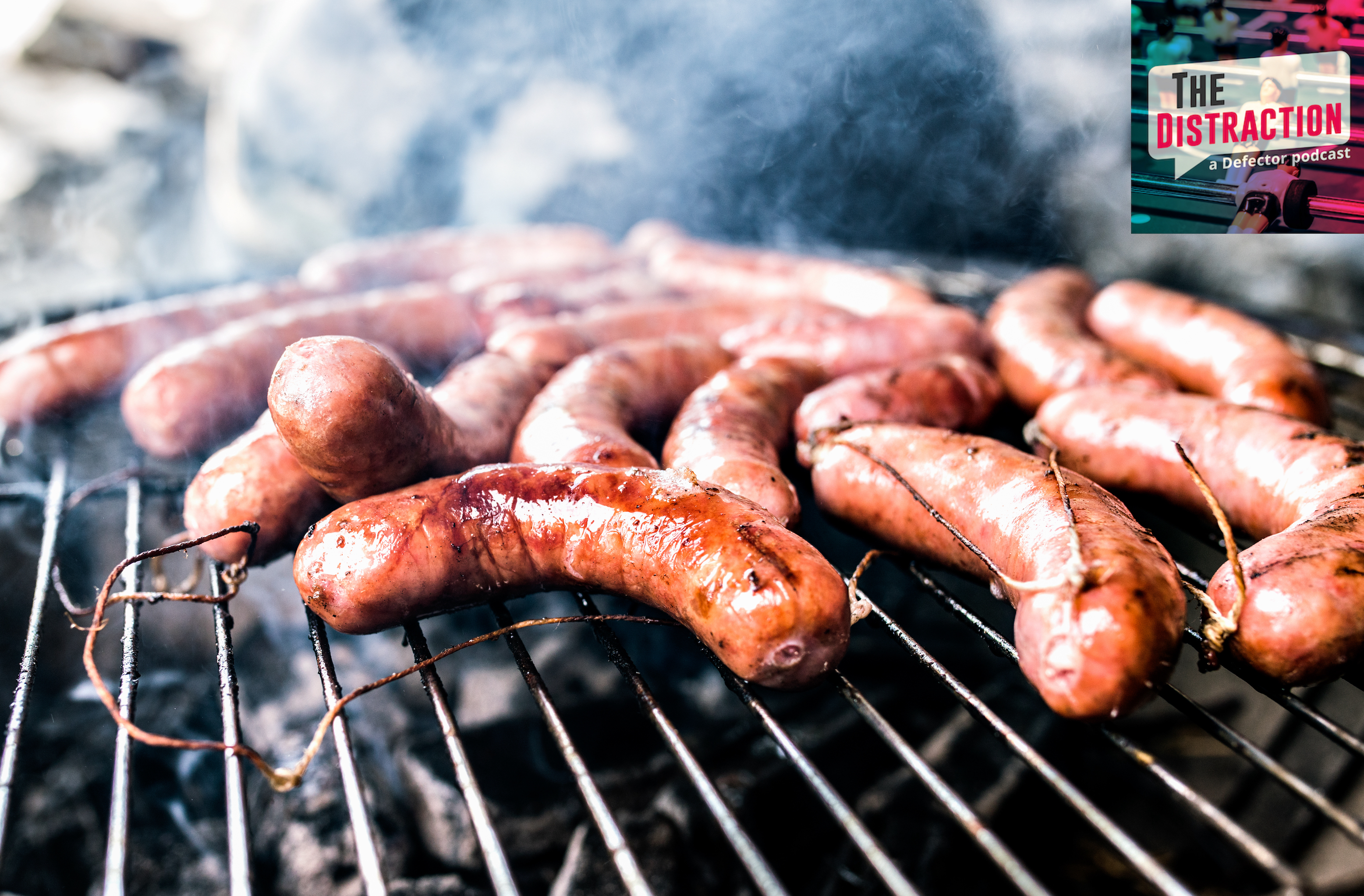 A stock photo of sausages cooking on a barbecue grill.