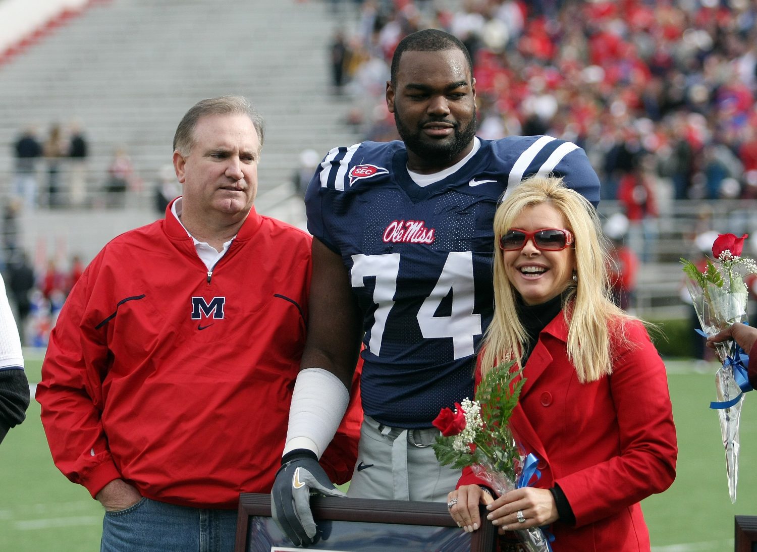Michael Oher #74 of the Ole Miss Rebels stands with his family during senior ceremonies prior to a game against the Mississippi State Bulldogs.
