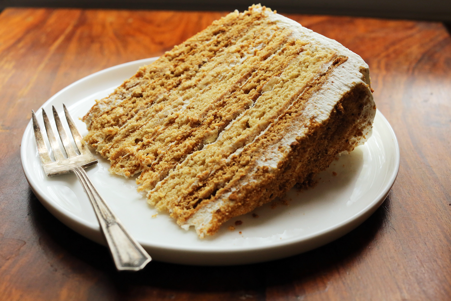 A slice of cake on a plate with a fork.