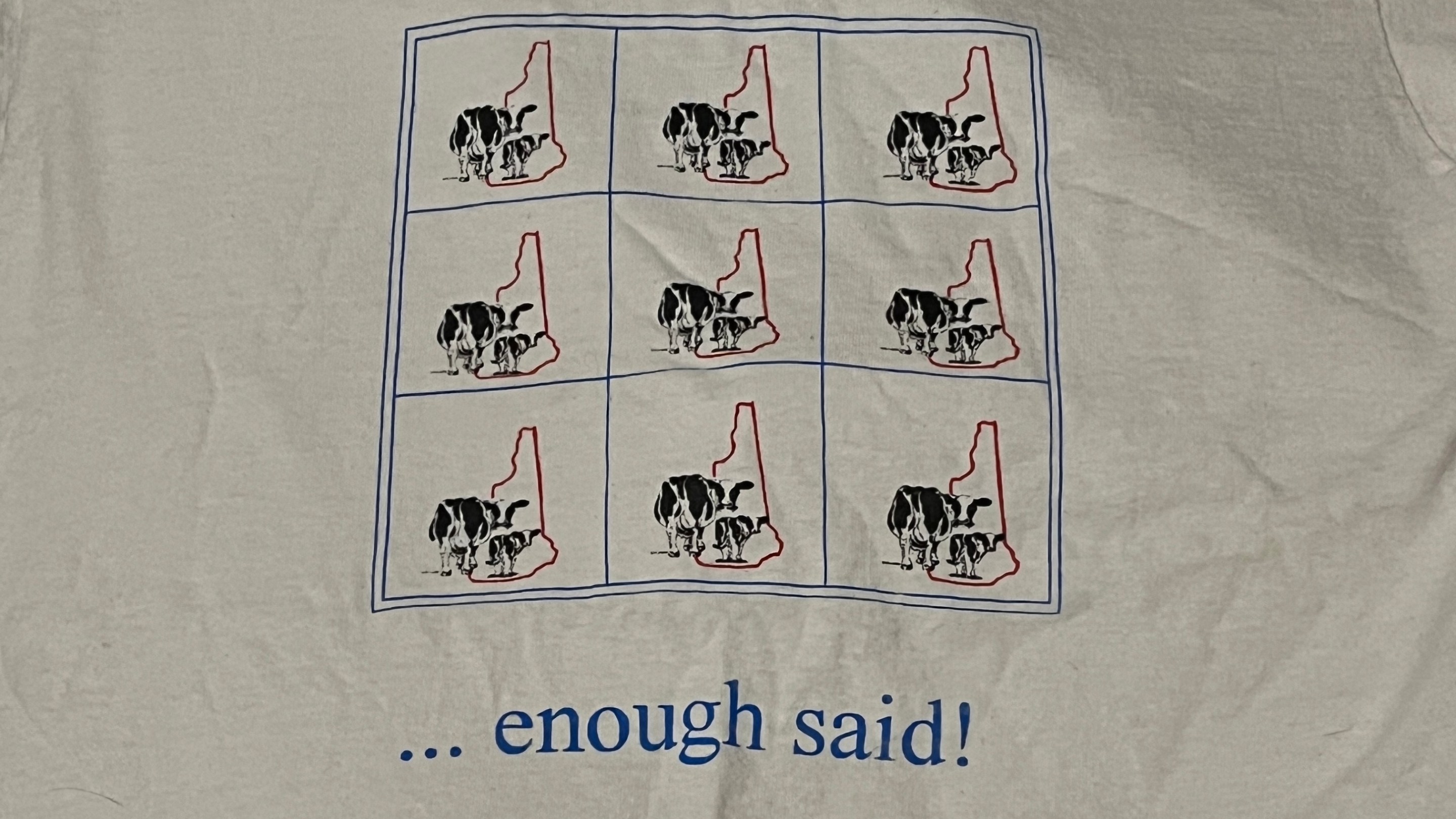 A t-shirt with a three-by-three grid. Each box has two cows standing in front of the state of New Hampshire. The bottom of the shirt says "... enough said!"