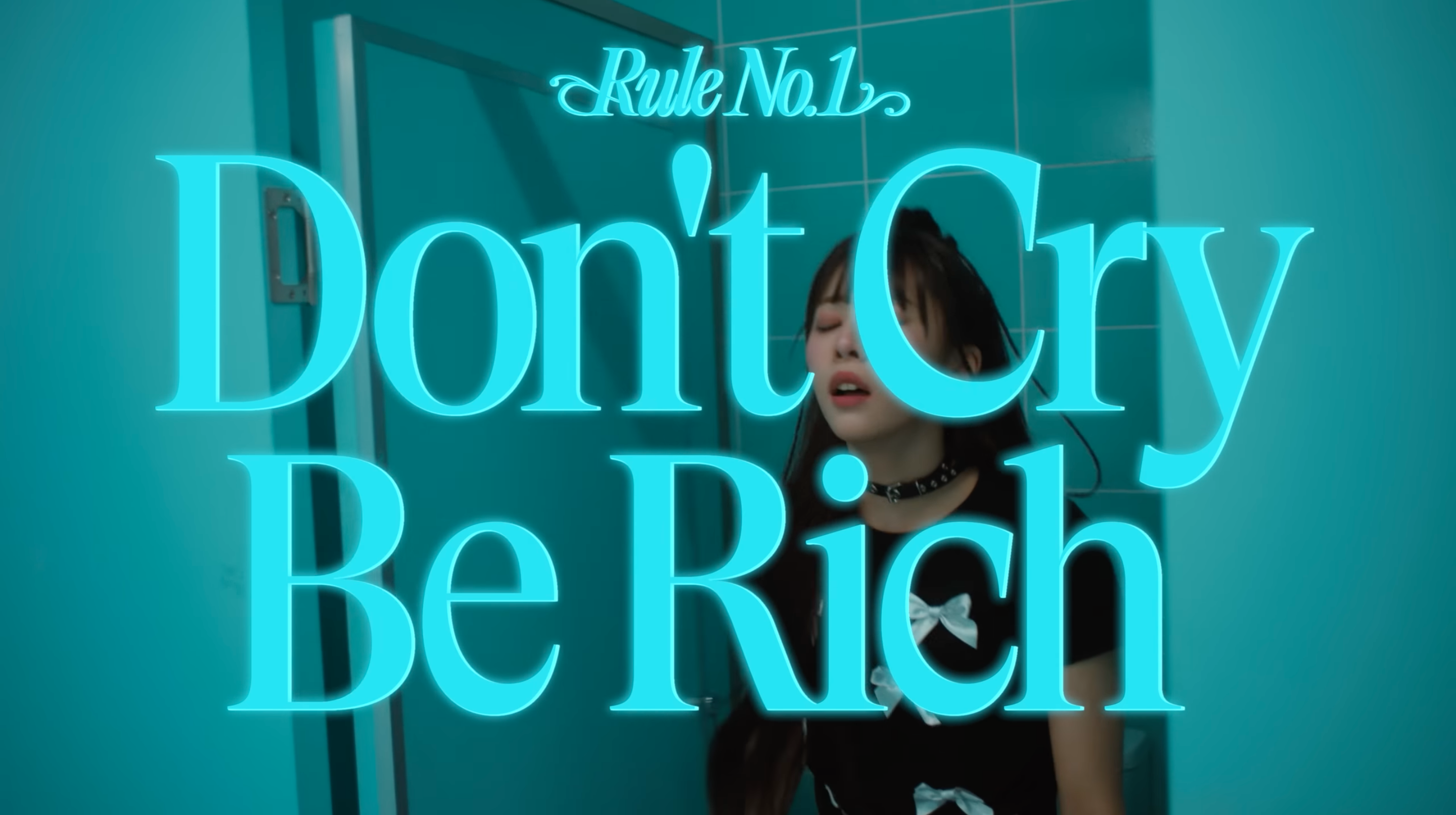 Screenshot from tripleS LOVElution's "Girls' Capitalism" music video, with text reading, "Rule No. 1 Don't Cry Be Rich."