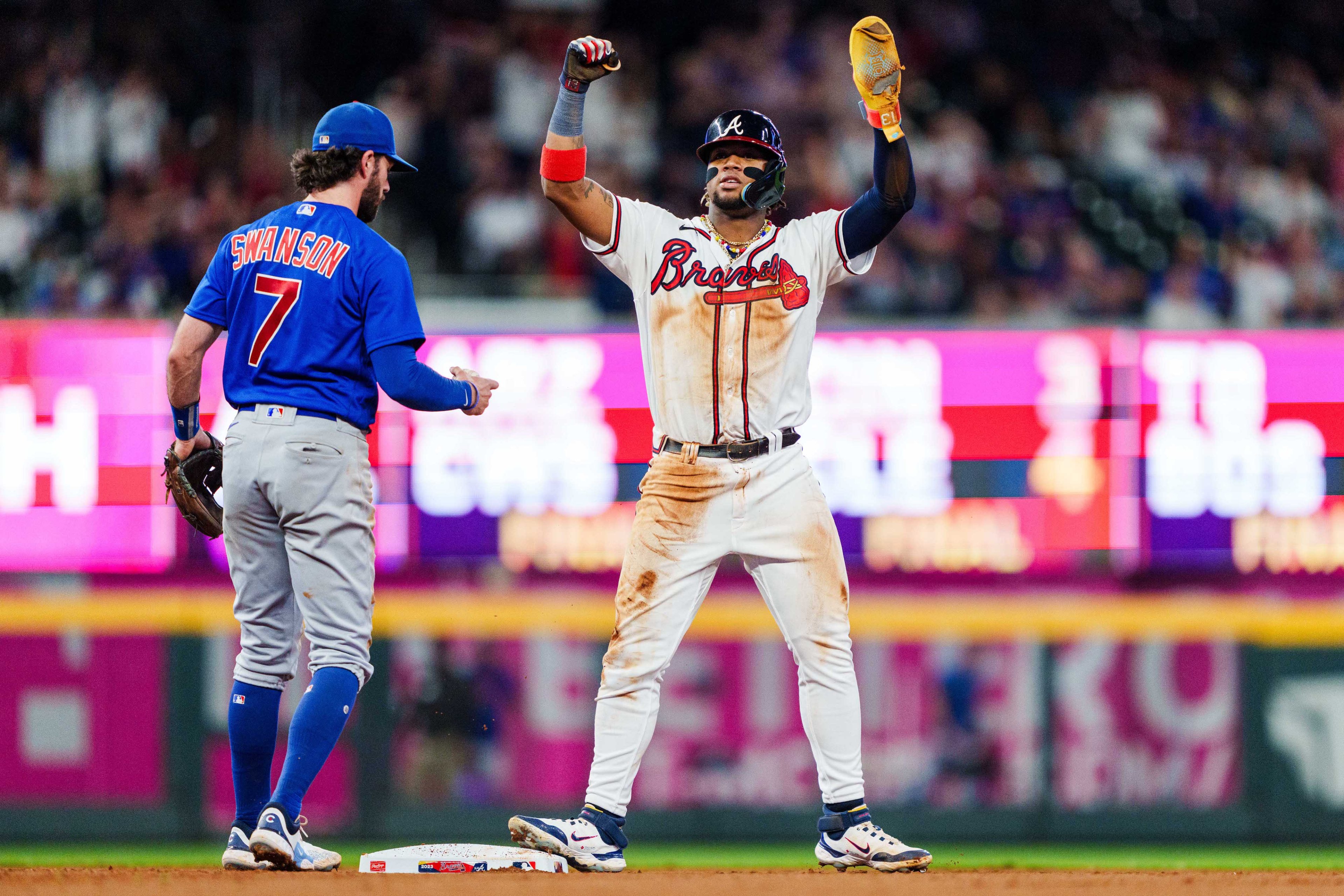 Ronald Acuña Jr. #13 of the Atlanta Braves celebrates after stealing second base in the tenth inning against the Chicago Cubs at Truist Park on September 27, 2023 in Atlanta, Georgia. Acuña Jr. is the first player in MLB history to hit 40 home runs and steal 70 bases in a single season.