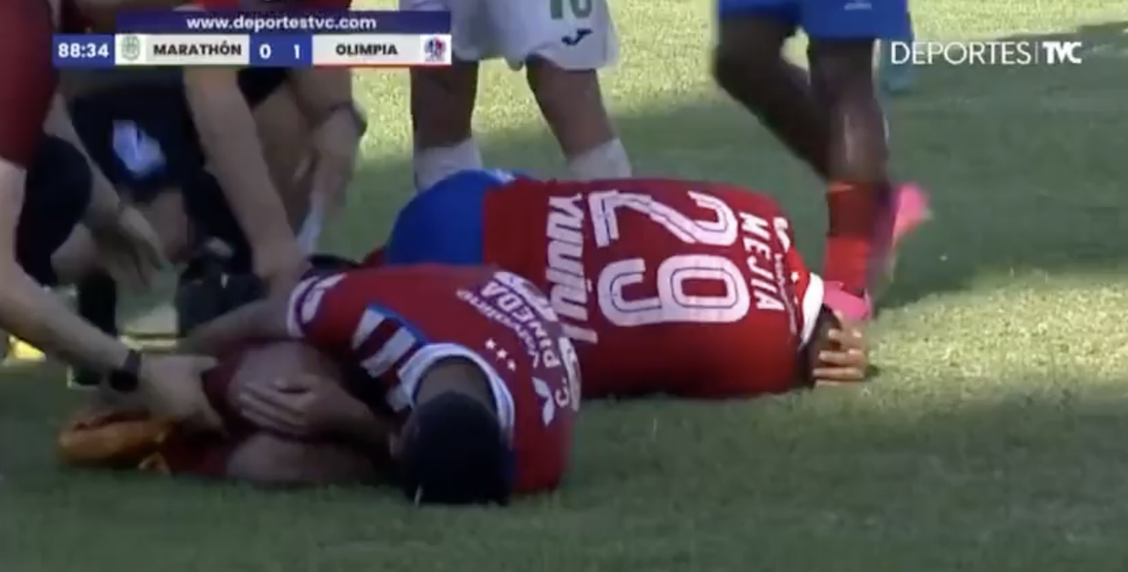 Two Olimpia players stay down after being tackled.