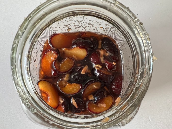 Sliced plums and minced ginger soak in melted sugar.