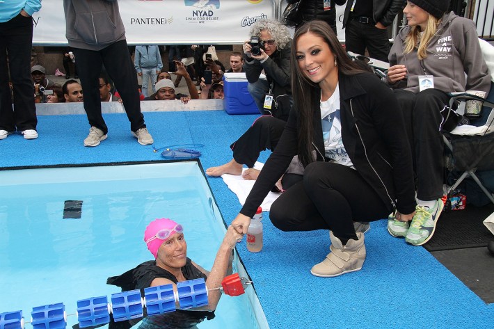Diana Nyad, in a pool for a Good Morning America swim stunt for Hurricane Sandy relief, bumps fists with Sammi Sweetheart from Jersey Shore. Sammi is not in the pool.