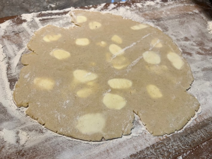 Rolled-out biscuit dough with large pale smears of unmixed butter throughout. This dough would never have worked.