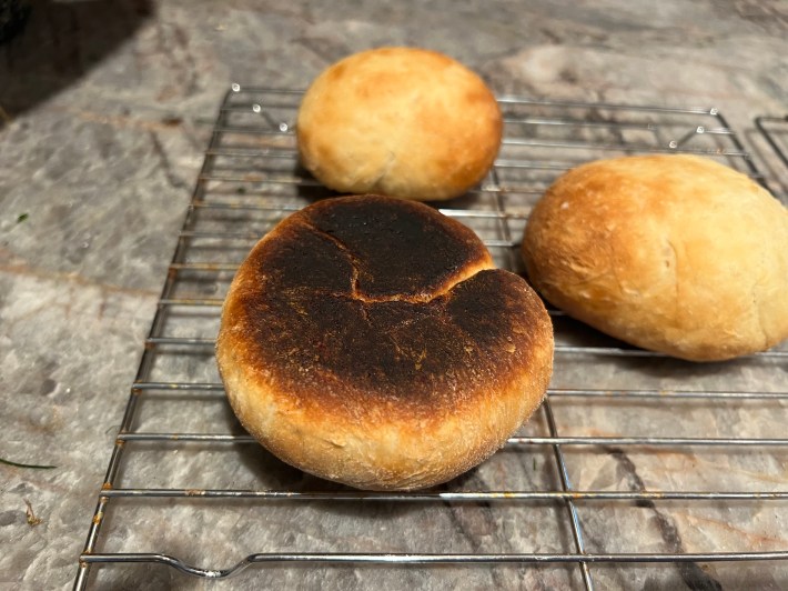 A baked bun flipped over to show a charred bottom.