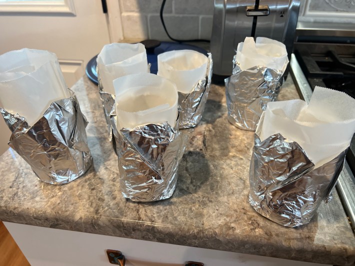 Six cylindrical molds made out of tin foil and parchment paper.