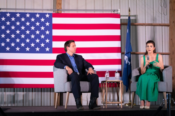 DeSantis wears extremely large boots while sitting on stage. Once again his lower legs look oddly shaped and impossibly long.