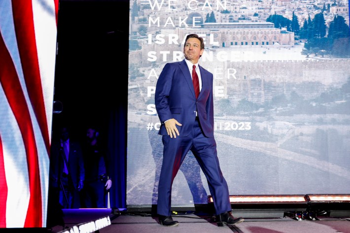 Ron DeSantis takes another step onto the stage, accentuating the strange extra angle in his left leg.